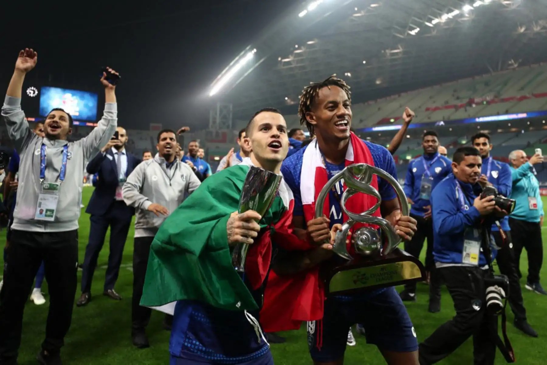 Abdullah Otayf  y Andre Carrillo de Al-Hilal celebran con el trofeo después de su victoria por 2-0 y el título del club asiático en el partido de vuelta de la final de la Liga de Campeones de la AFC entre el Urawa Red Diamonds de Japón y el Al de Arabia Saudita -Hilal en Saitama el 24 de noviembre de 2019. Foto :ANDINA/AFP