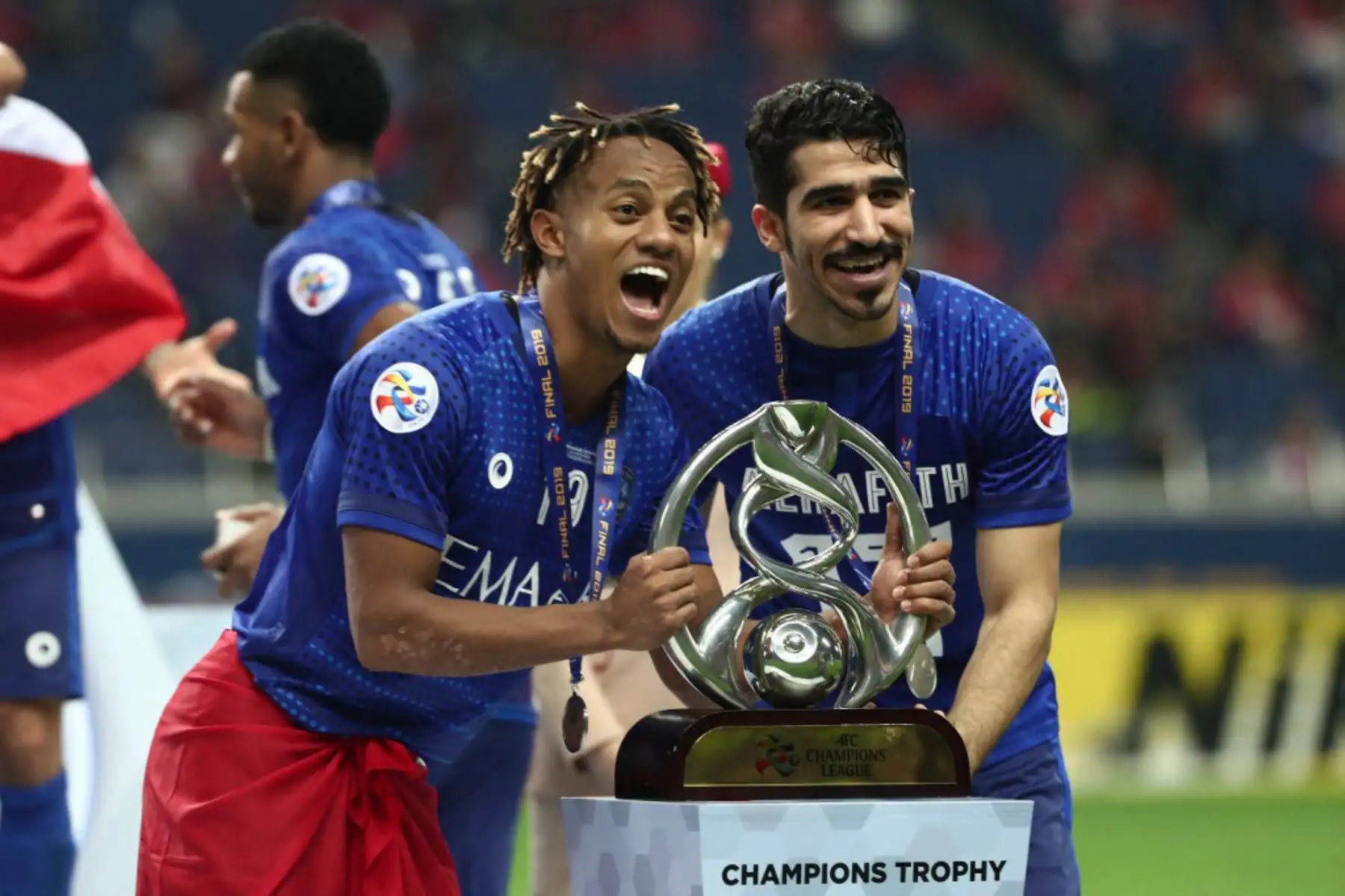 Abdullah al-Hafith  y Andre Carrillo de Al-Hilal celebran con el trofeo después de su victoria por 2-0 y el título del club asiático al final del partido de vuelta de la final de la Liga de Campeones de la AFC entre el Urawa Red Diamonds de Japón. y Al-Hilal de Arabia Saudita en Saitama el 24 de noviembre de 2019. Foto: ANDINA/ AFP