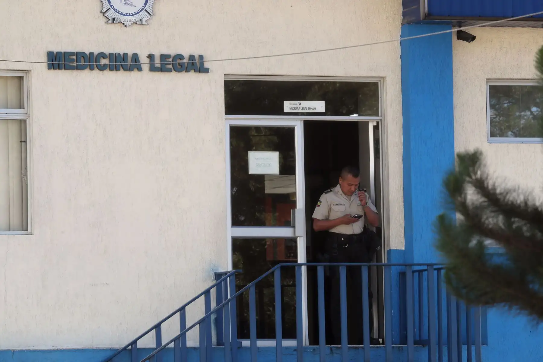 Un policía observa un teléfono móvil a la entrada de la morgue del Servicio Nacional de Ciencias Forenses a la cual fue llevado el cuerpo del candidato presidencial Fernando Villavicencio hoy, en Quito (Ecuador). Foto: EFE