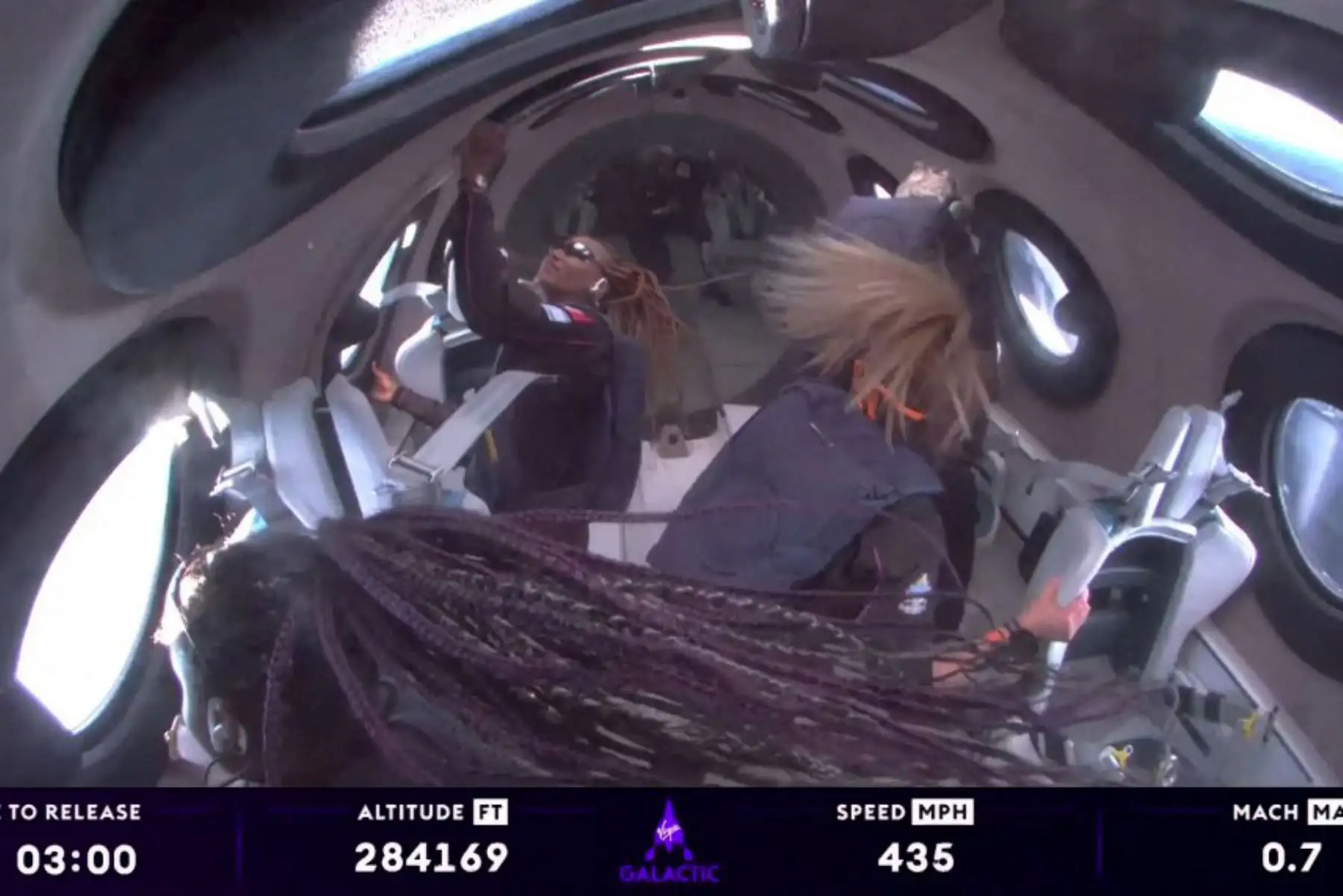 Esta imagen fija tomada de un video de Virgin Galactic, muestra a Anastatia Mayers, Jon Goodwin y la instructora jefe de astronautas Beth Moses, mirando por las ventanas en el espacio, después de que la misión de astronautas privados Galactic 02 de Virgin Galactic se lanzara desde el puerto espacial América en Truth or Consequences, Nuevo México. Foto: AFP