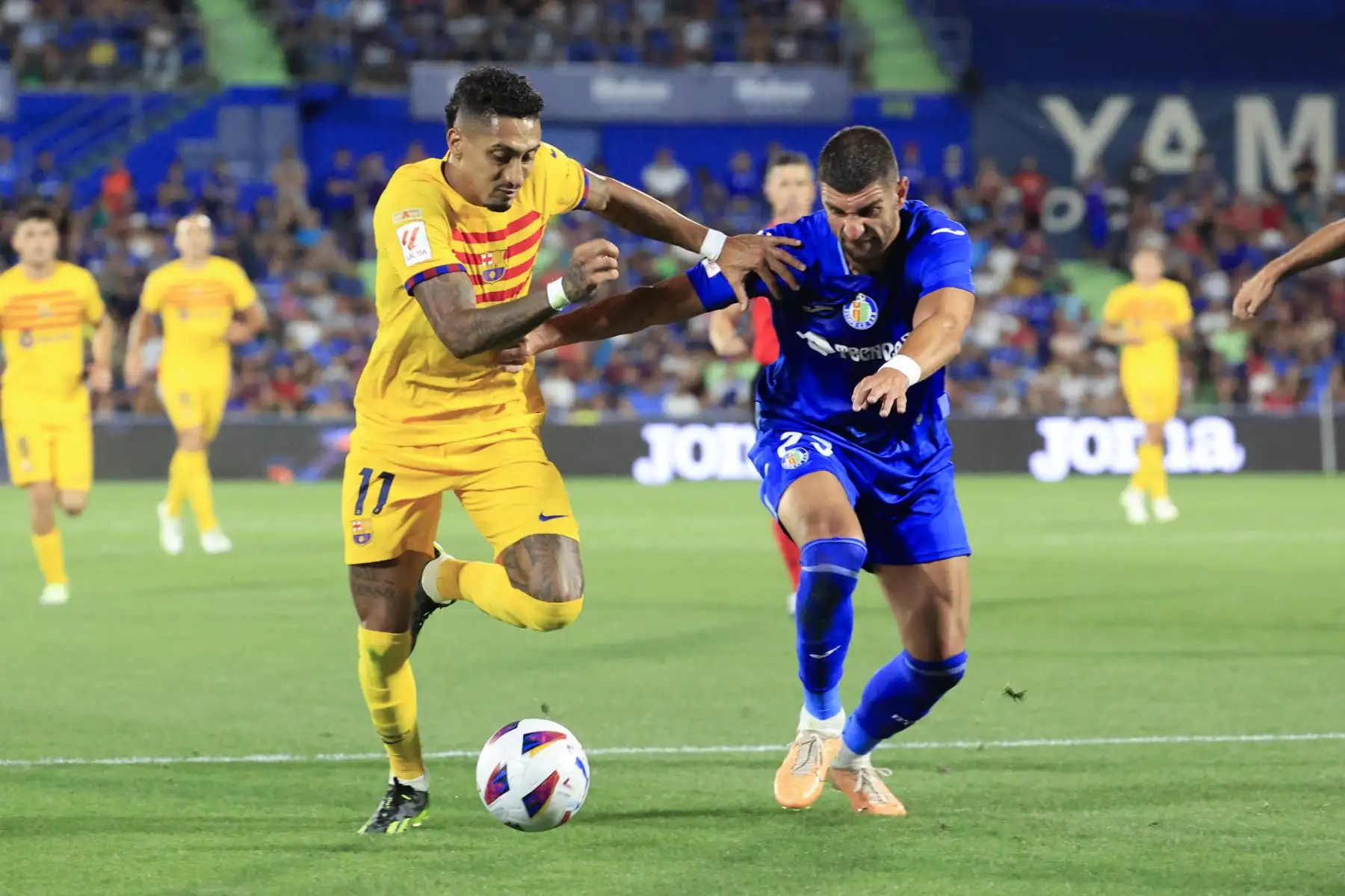El delantero brasileño del FC Barcelona Raphinha (i) disputa un balón ante Stefan Mitrovic, defensa Serbio del Getafe durante el partido de la primera jornada de LaLiga que disputan este domingo en el Coliseum Alfonso Pérez.
Foto: EFE