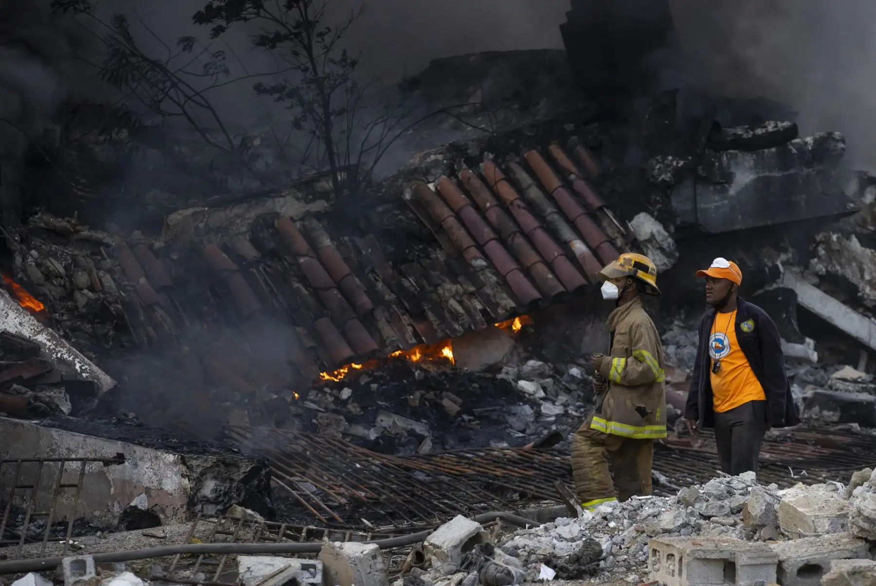Bomberos intentan controlar el incendio provocado por una fuerte explosión de origen desconocido ocurrida en una zona comercial de San Cristóbal, en República Dominicana, donde ya van al menos tres fallecidos y varias personas heridas. Foto: EFE