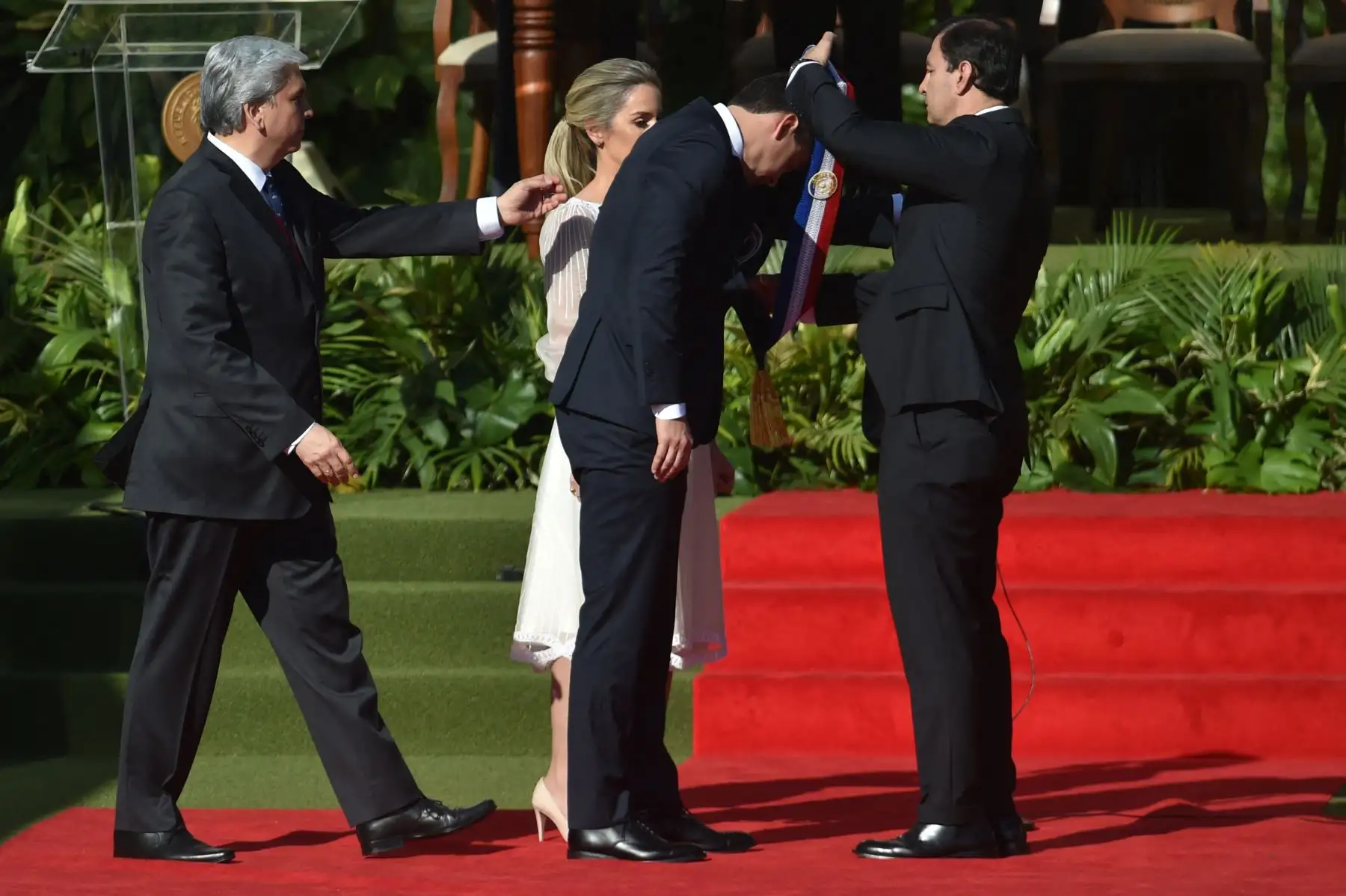 El nuevo presidente de Paraguay, Santiago Peña, recibe la banda presidencial de manos del presidente del Senado, Silvio Ovelar, junto a su esposa, la primera dama, Leticia Ocampos, durante su toma de posesión en la explanada del Palacio Presidencial López en Asunción el 15 de agosto de 2023.
Foto: AFP