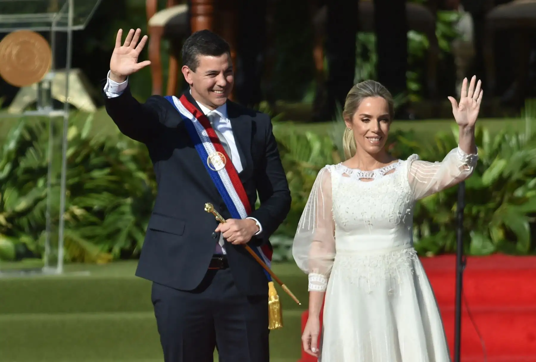 El nuevo presidente de Paraguay, Santiago Peña, y su esposa, la primera dama, Leticia Ocampos, saludan durante su toma de posesión en la explanada del Palacio Presidencial López en Asunción el 15 de agosto de 2023.
Foto: AFP