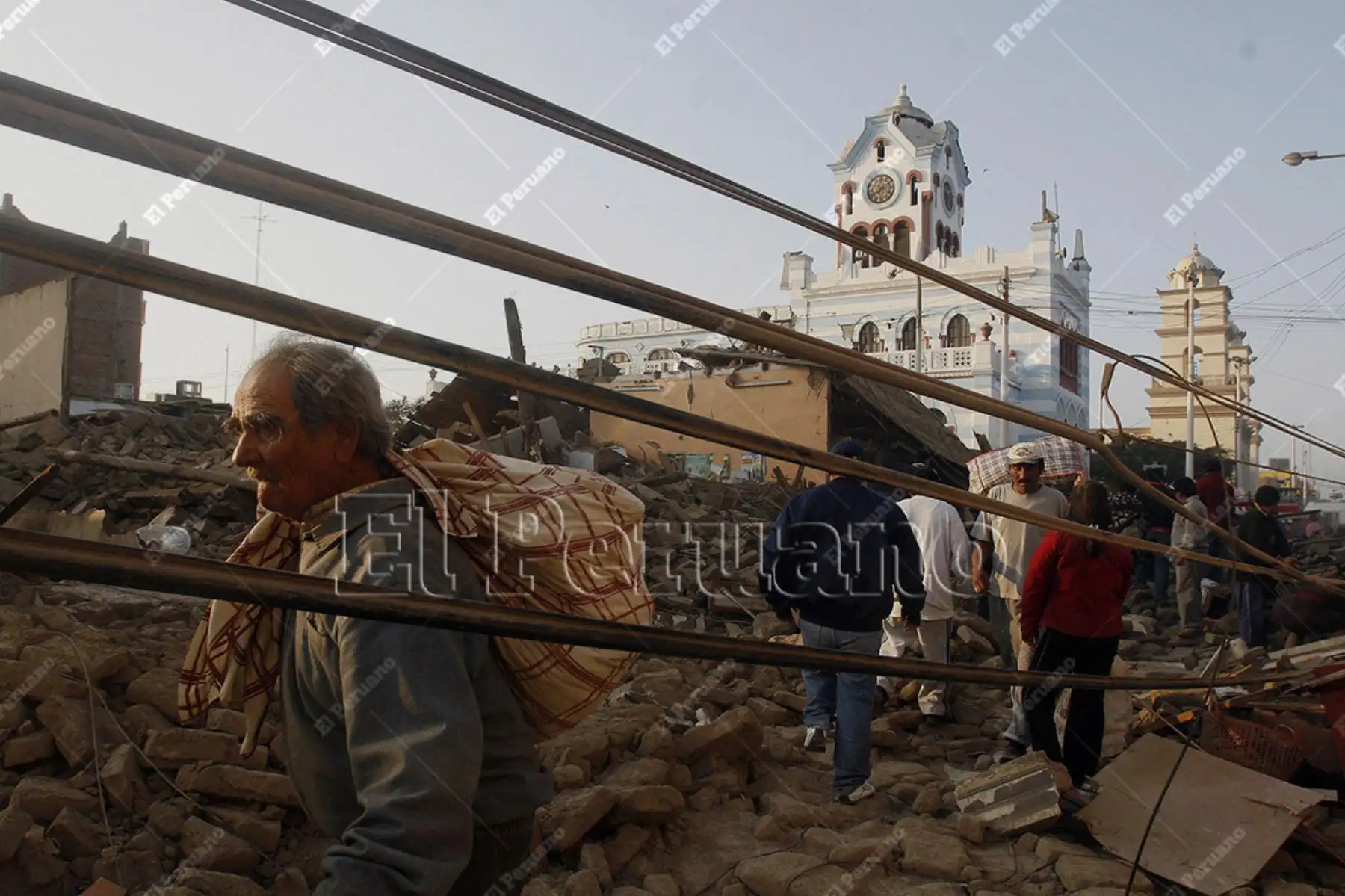 Pisco, Ica - 16 agosto 2007 / Damnificados por el terremoto caminan con pertenencias en la calle San Juan de Dios. Foto: El Peruano / Alberto Orbegoso.