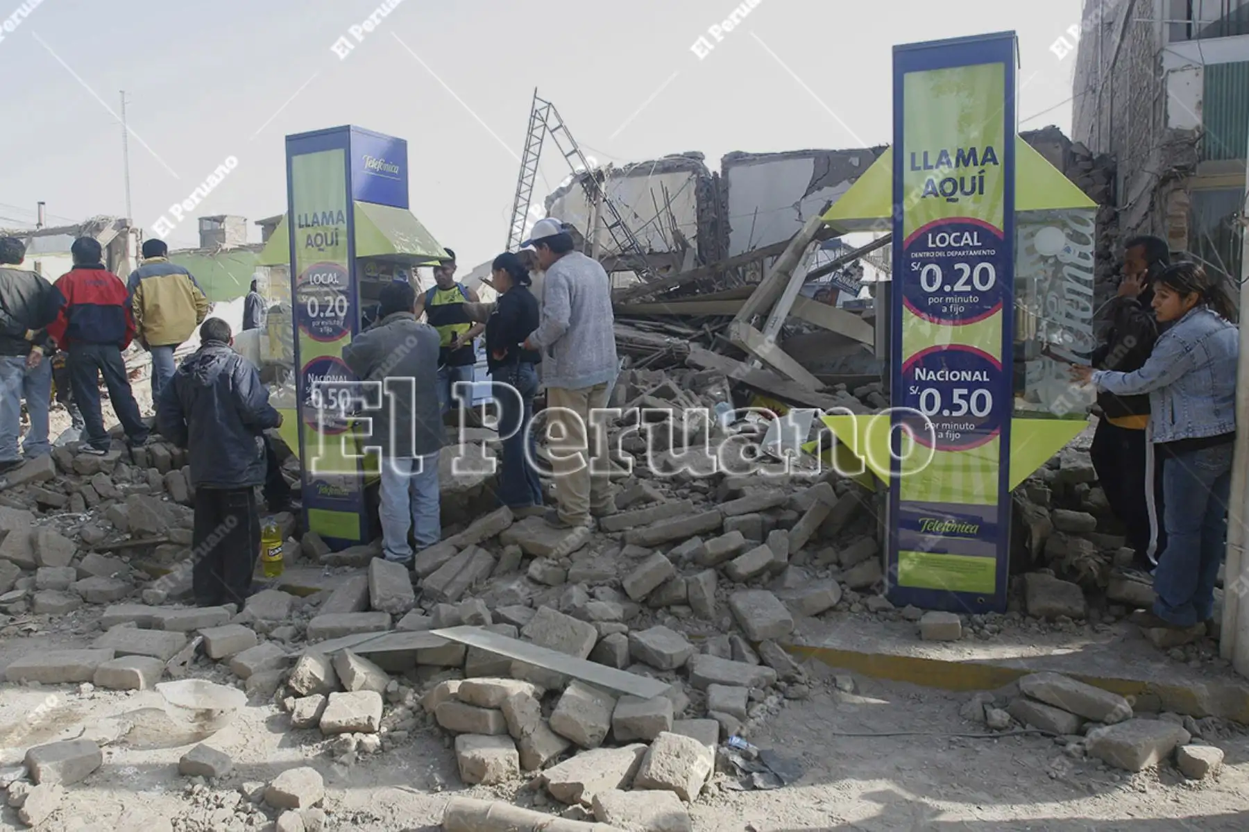Pisco, Ica – 16 agosto 2007 / Pobladores buscan comunicarse a través de los teléfonos públicos, sobre los escombros después del terremoto. Foto: El Peruano / Alberto Orbegoso
