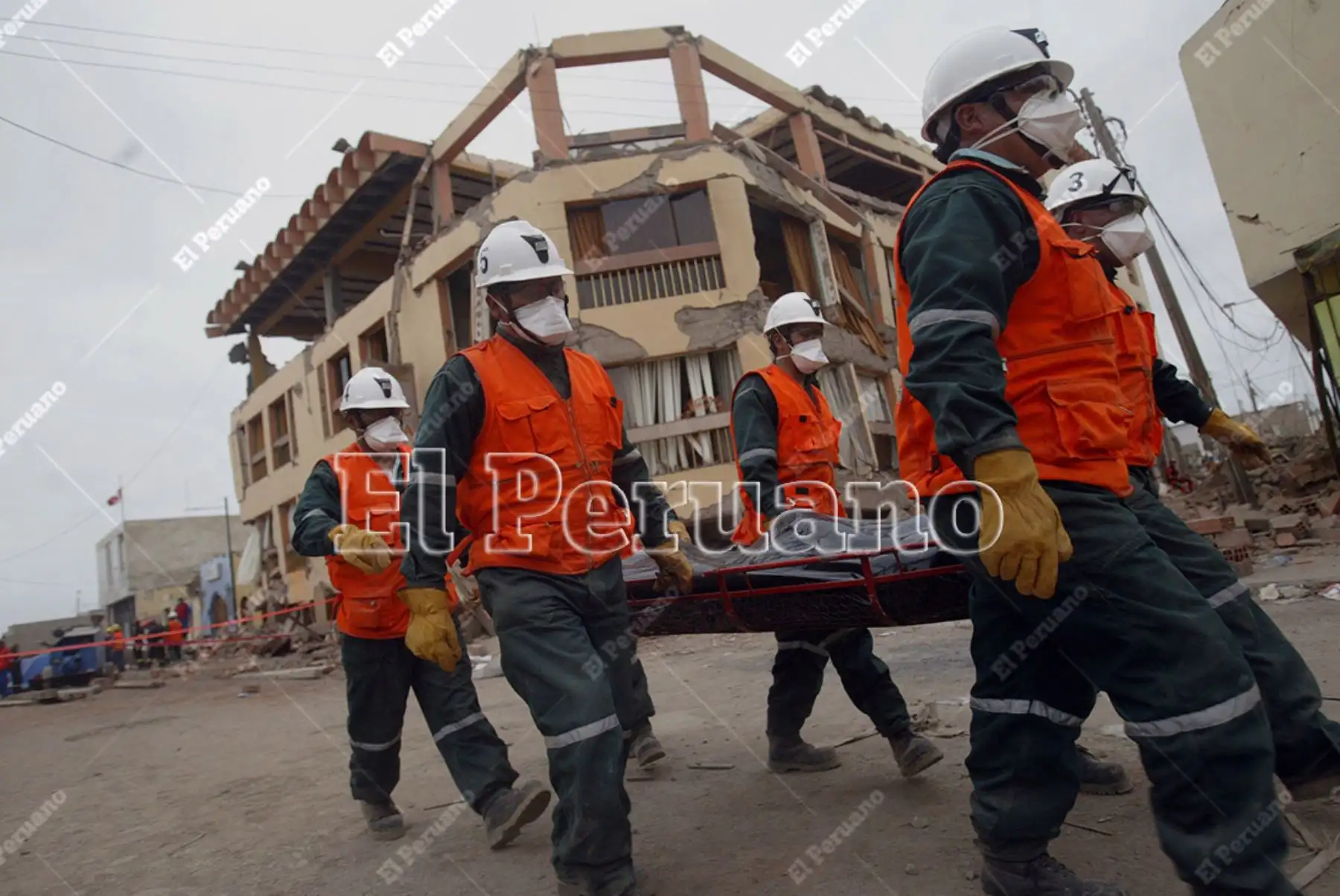 Pisco, Ica - 18 agosto 2007 / Rescatistas trasladan fallecidos a consecuencia del terremoto y pasan frente al edificio del Hotel Embassy  totalmente dañado. Foto: El Peruano / Juan Carlos Guzmán