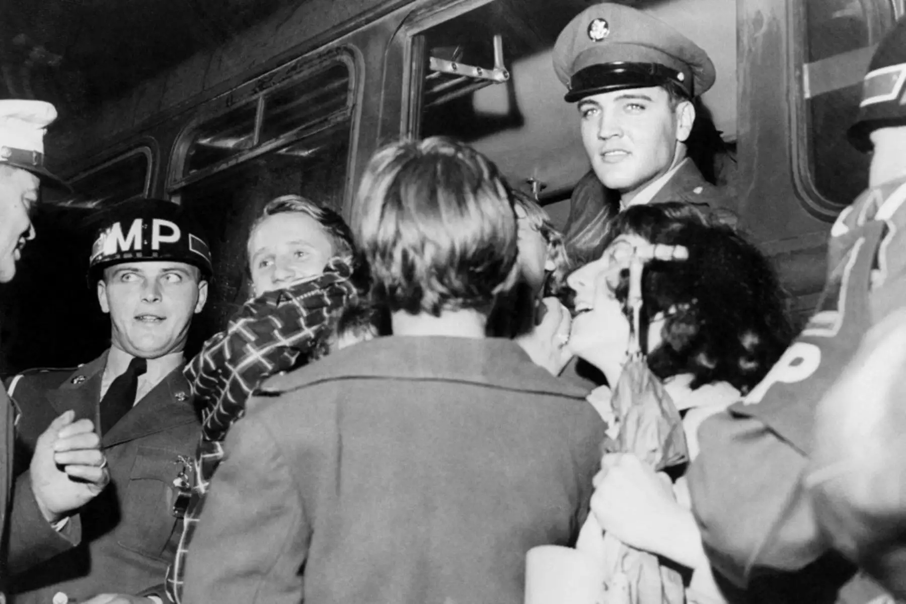 Fotografía tomada en 1959 en Alemania de la estrella de rock estadounidense Elvis Presley (centro) vitoreado por los fanáticos a su llegada a Friedberg para hacer su servicio militar. Elvis pasó dos años en Alemania mientras estaba en el ejército de los Estados Unidos. Foto:ANDINA/AFP