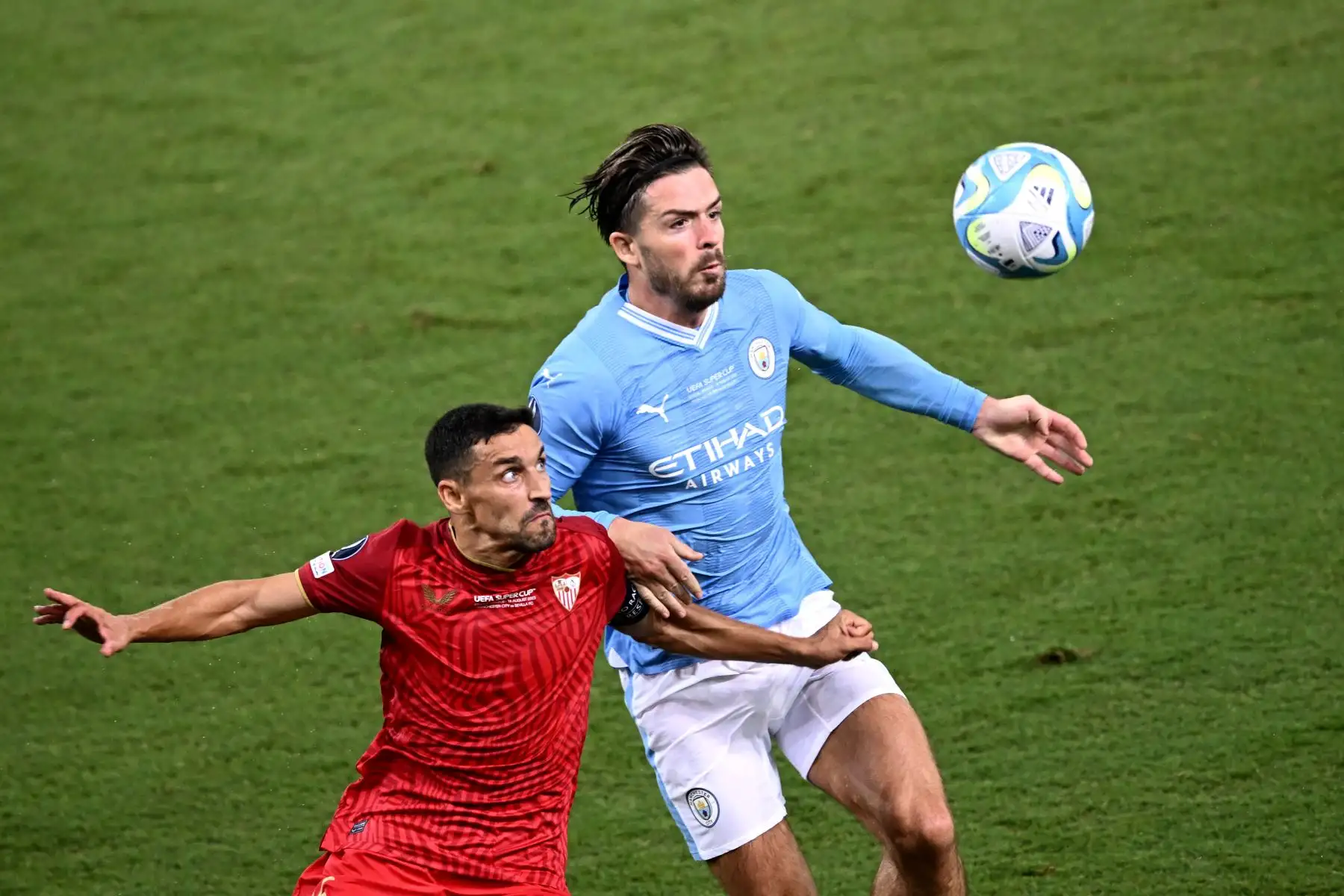 El centrocampista español del Sevilla 16 Jesús Navas lucha por el balón con el centrocampista inglés del Manchester City 10 Jack Grealish durante el partido de fútbol de la Supercopa de la UEFA de 2023 entre el Manchester City y el Sevilla en el estadio Georgios Karaiskakis de El Pireo. Foto:ANDINA/AFP
