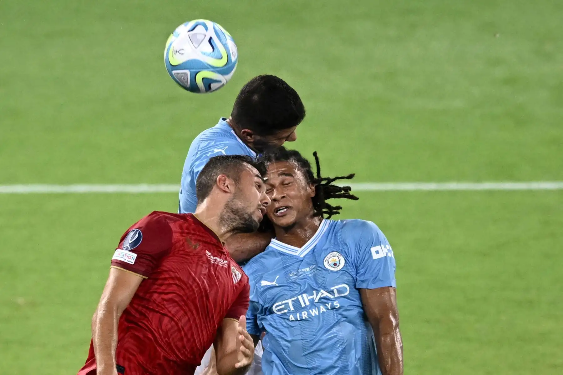El centrocampista español del Sevilla 08 Joan Jordan Moreno  lucha por el balón con el defensor holandés 06 Nathan Ake  del Manchester City durante el partido de fútbol de la Supercopa de la UEFA 2023 entre el Manchester City y el Sevilla en el Estadio Georgios Karaiskakis en El Pireo. Foto:ANDINA/AFP