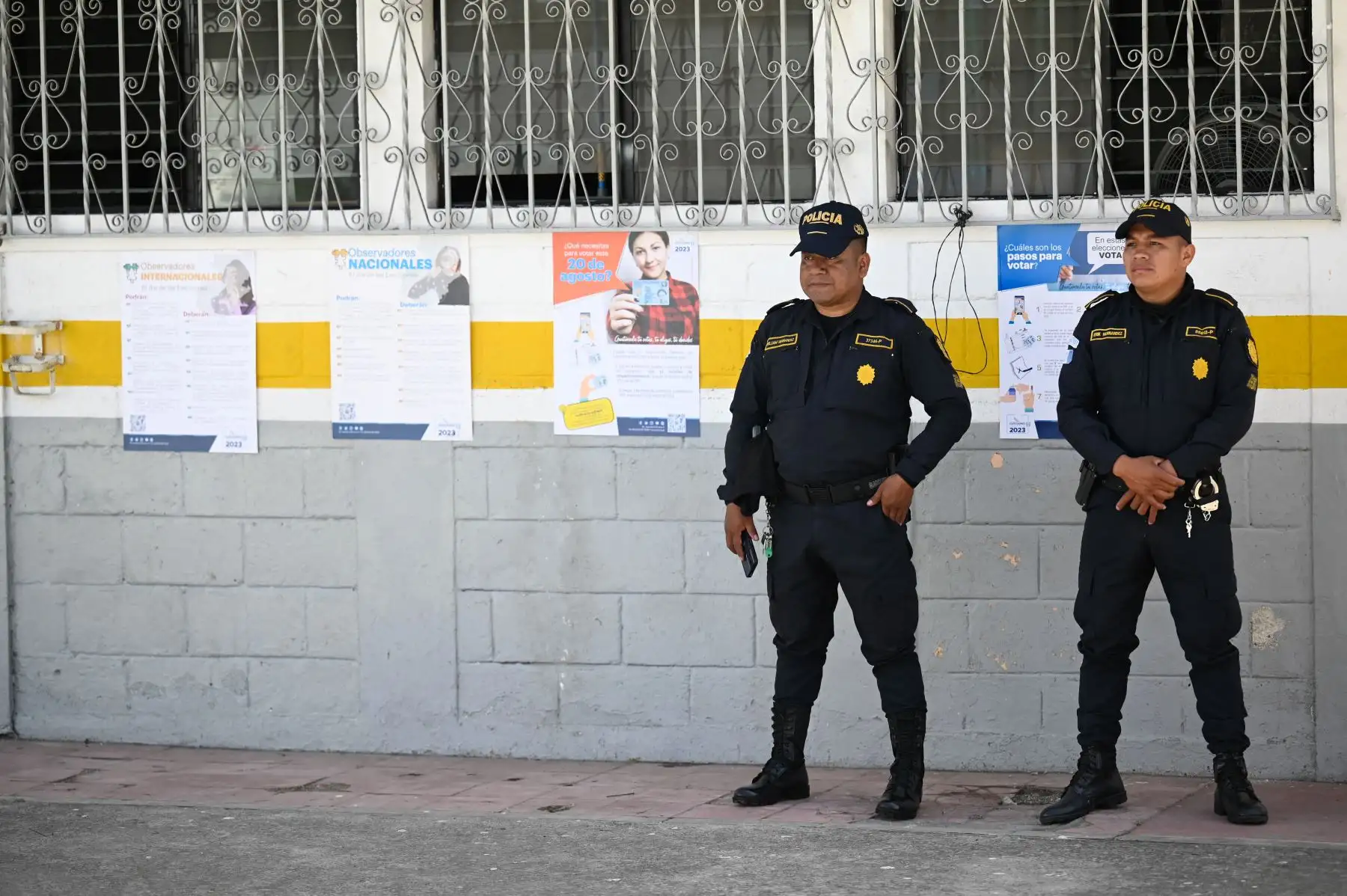 Oficiales de policía montan guardia frente a una escuela donde se instalarán los colegios electorales en el pueblo de Puerta Parada, Santa Catarina Pinula, Guatemala.
Foto: AFP