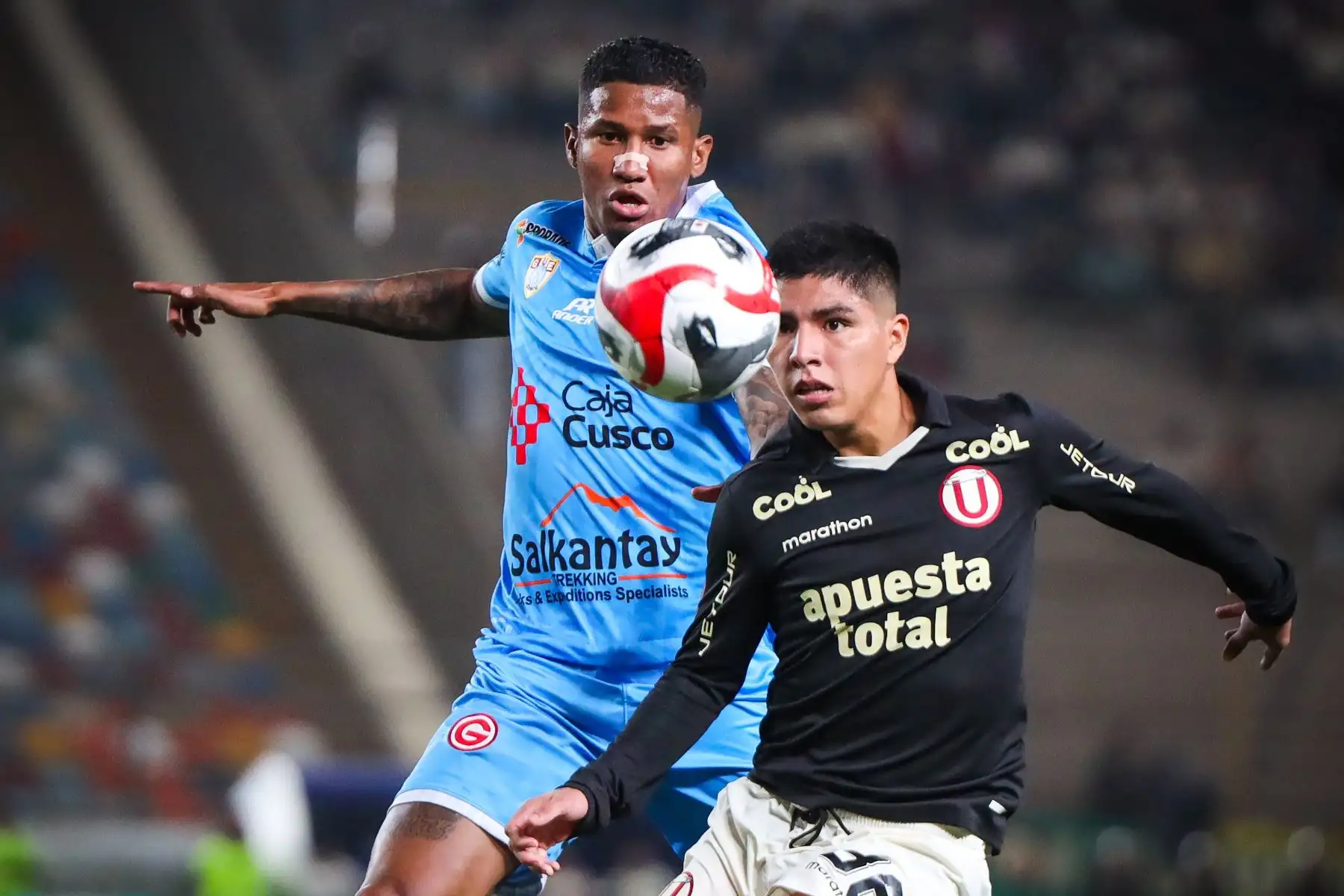 El jugador Piero Quispe de Universitario de Deportes disputa el balón ante el jugador del Deportivo Garcilaso por la fecha 10 del Torneo Clausura en el estadio Monumental de Ate. 
Foto: Universitario de Deportes