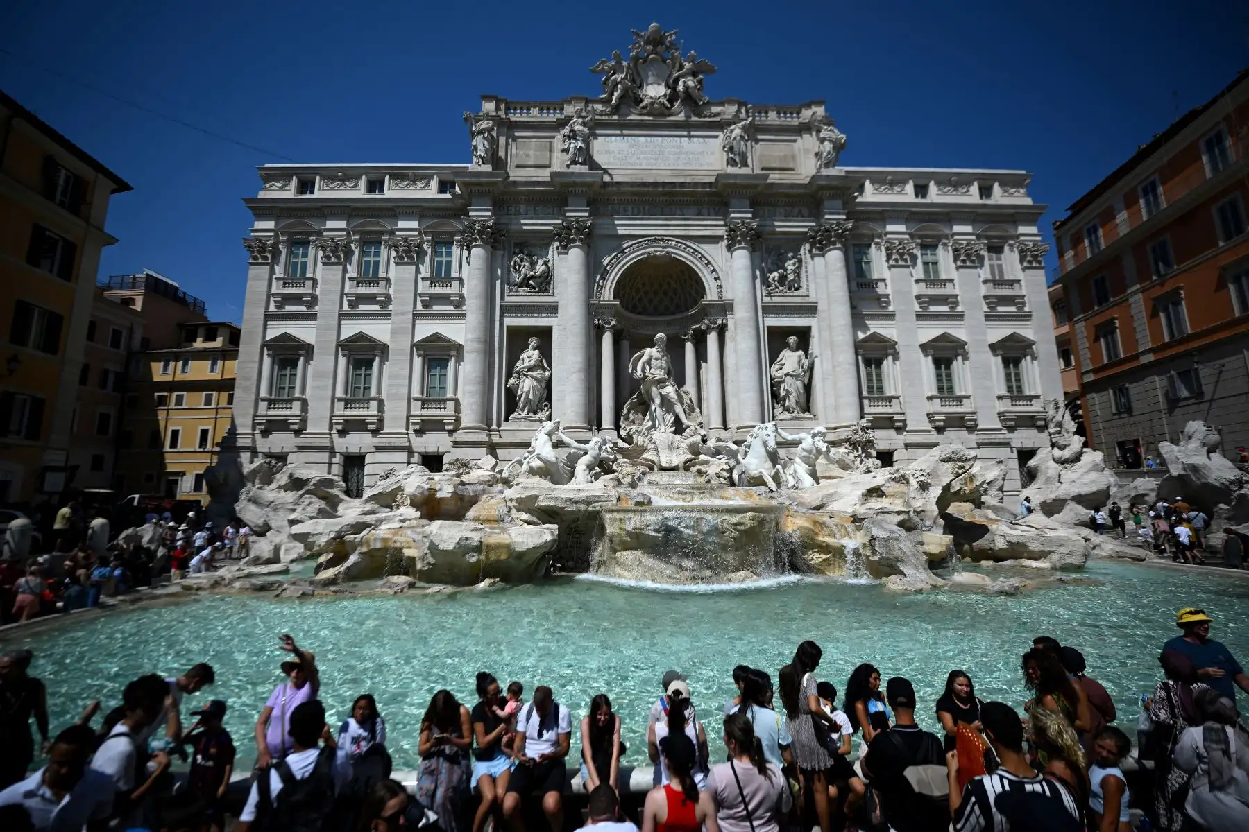 Los turistas se refrescan en la Fontana de Trevi durante una ola de calor en Roma. Foto:ANDINA/AFP