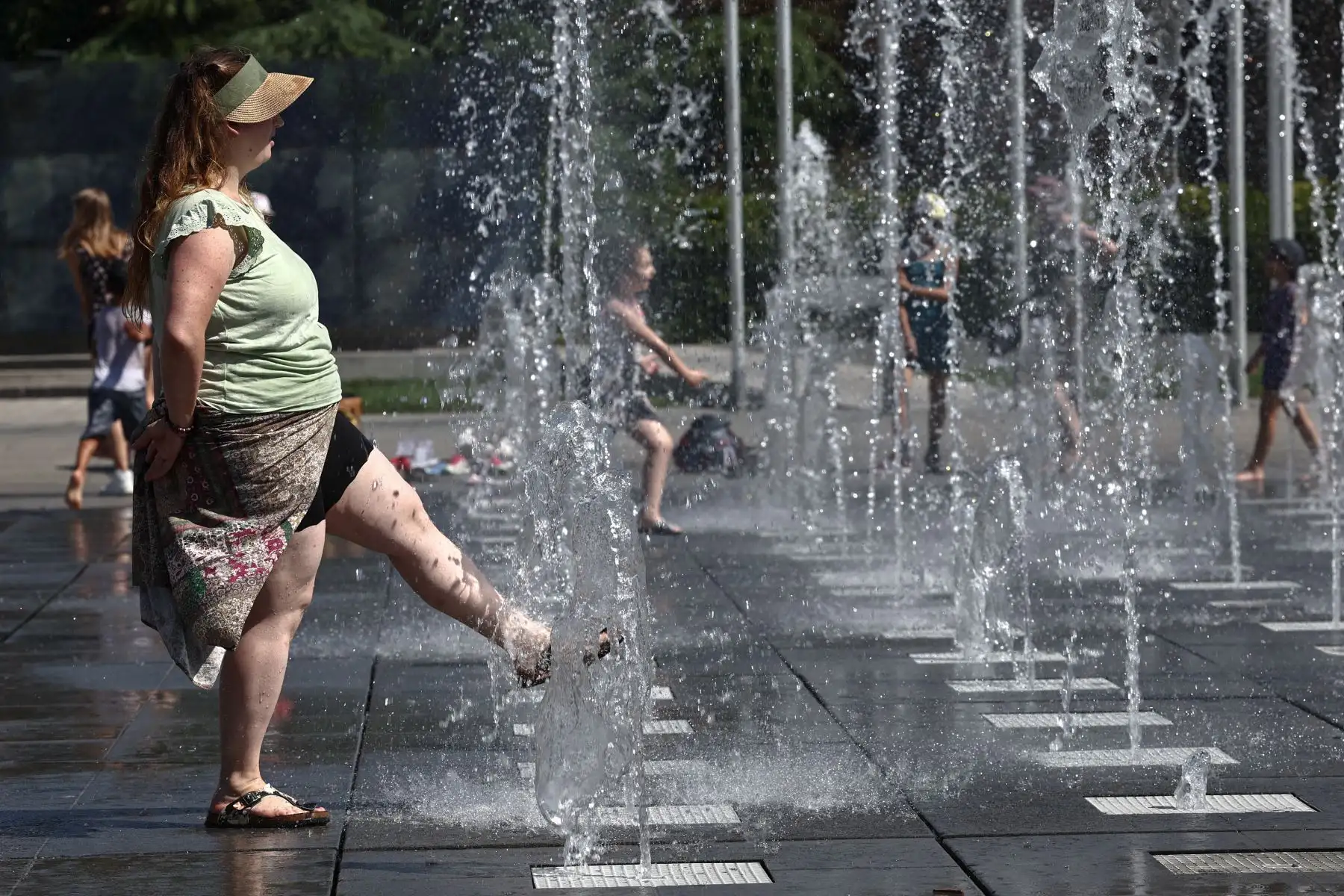 Una mujer se refresca en una fuente pública en Colmar, este de Francia, mientras Francia experimenta una ola de calor a fines del verano. Foto: AFP
