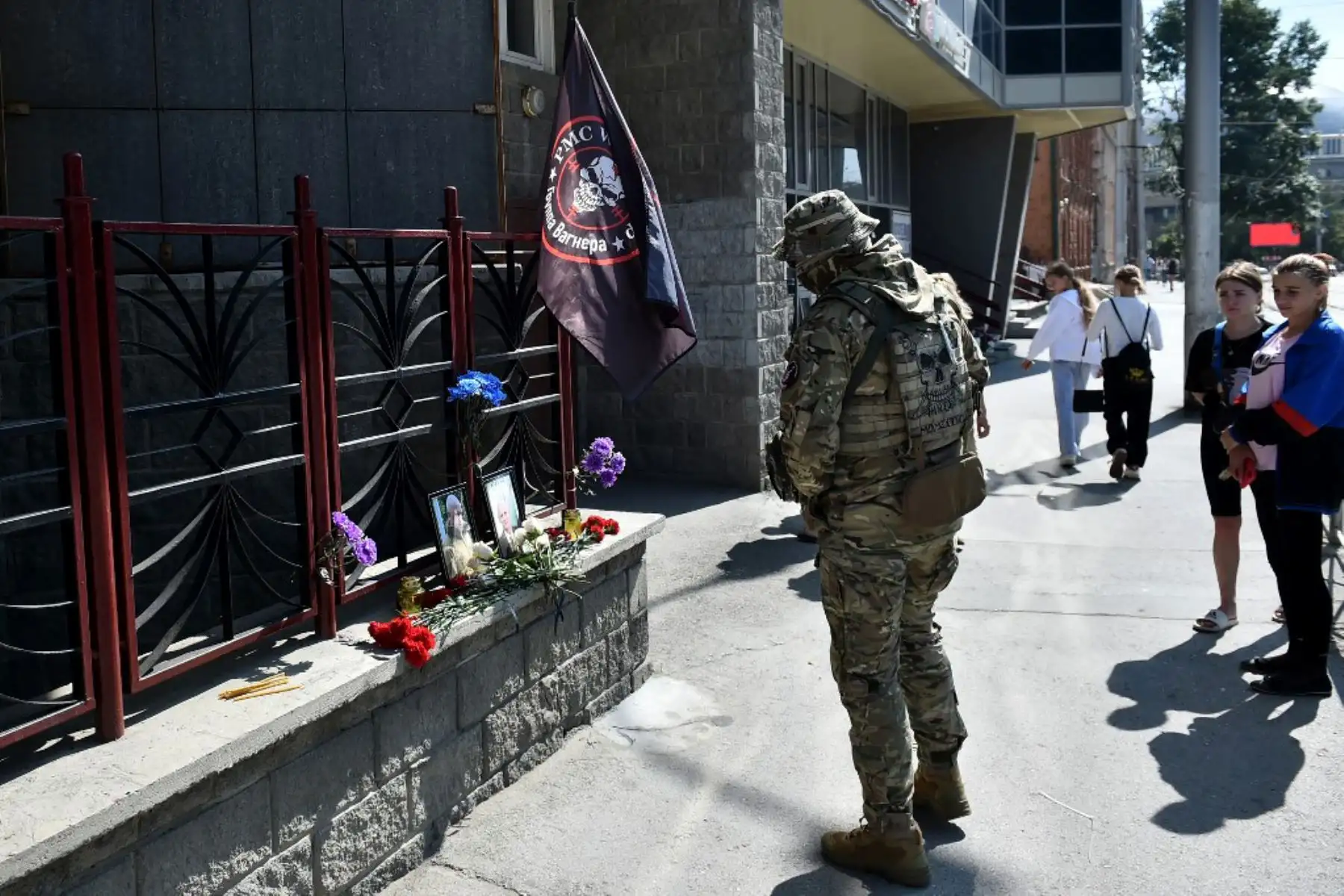 Un miembro del grupo mercenario privado Wagner rinde homenaje a Yevgeny Prigozhin y Dmitry Utkin, una figura oscura que dirigió las operaciones de Wagner y supuestamente sirvió en la inteligencia militar rusa, en el memorial improvisado frente a la oficina de PMC Wagner en Novosibirsk. Foto: AFP