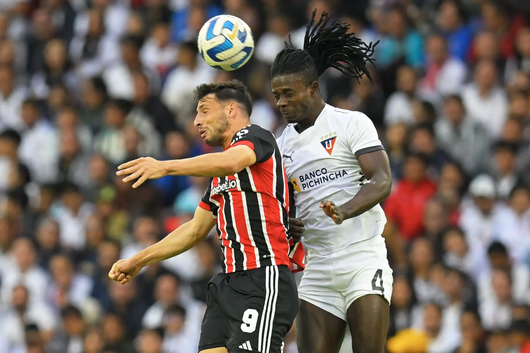 El delantero del Sao Paulo Jonathan Calleri y el defensa haitiano de la Liga de Quito Ricardo Ade compiten por el balón durante el partido de ida de los cuartos de final de la Copa Sudamericana entre la Liga de Quito de Ecuador y el Sao Paulo de Brasil, en el estadio Rodrigo Paz Delgado de Quito. Foto:ANDINA/AFP