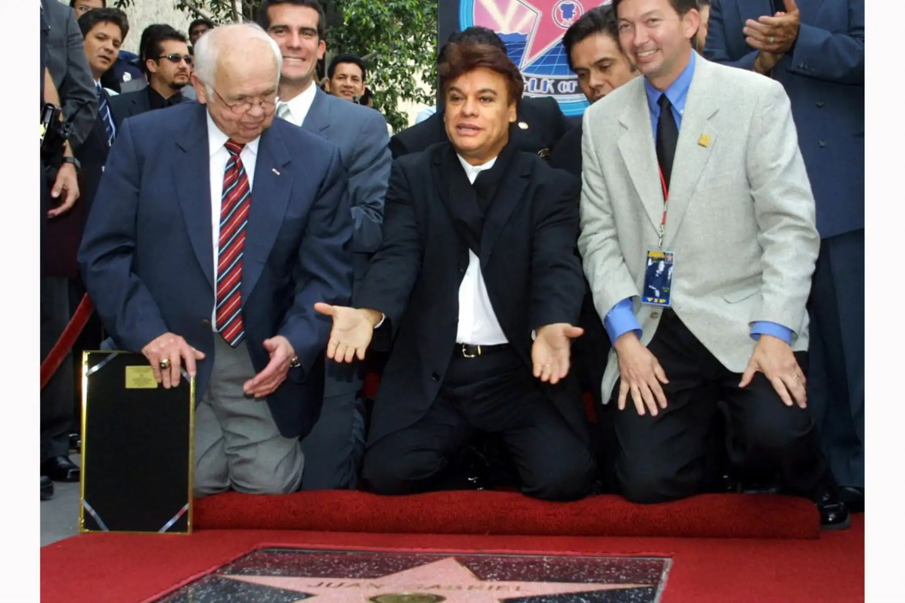 El cantante mexicano Juan Gabriel, muestra su agradecimiento mientras el alcalde honorario de Hollywood Johnny Grant y el presidente de la Cámara de Comercio de Hollywood Leron Gubler miran durante una ceremonia de inauguración de la estrella de Gabriel en el Paseo de la Fama de Hollywood el 10 de mayo de 2002 en Hollywood. , California. Foto: AFP