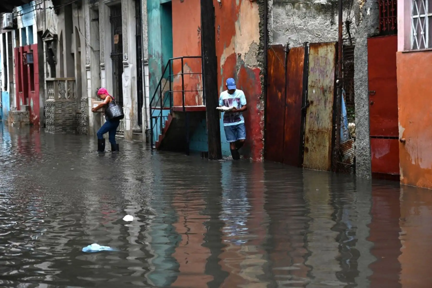Personas transitan por una calle inundada en La Habana, durante el paso de la tormenta tropical Idalia. La tormenta tropical Idalia se fortaleció hasta convertirse en huracán este martes y los meteorólogos pronostican que se volverá "extremadamente peligrosa" antes de tocar tierra el miércoles en Florida, Estados Unidos. Foto: AFP