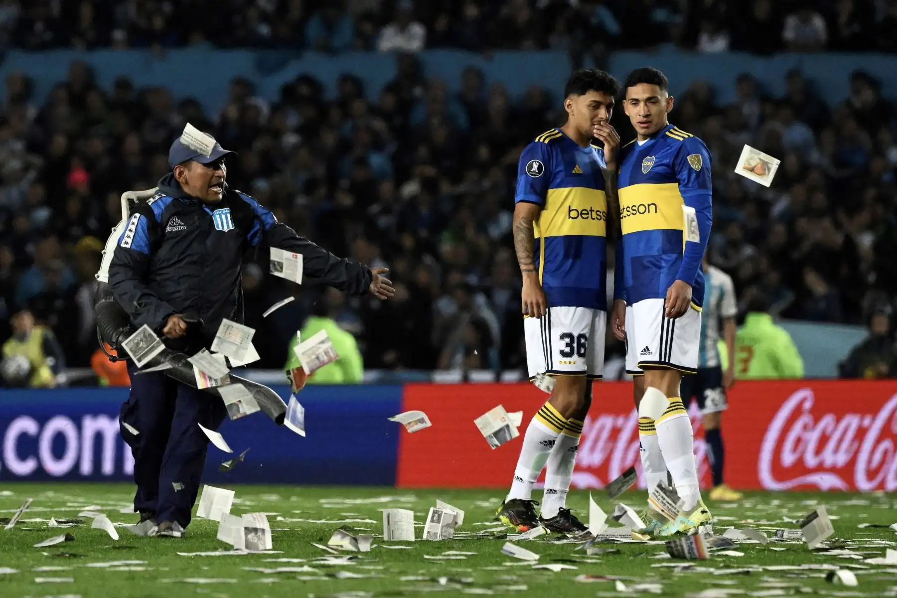 Los jugadores de Boca Juniors esperan que se reinicie el partido mientras los trabajadores limpian el papel arrojado al campo por los fanáticos de Racing durante el partido de vuelta de los cuartos de final de la Copa Libertadores Argentina entre Racing Club y Boca Juniors. Foto: ANDINA/ AFP