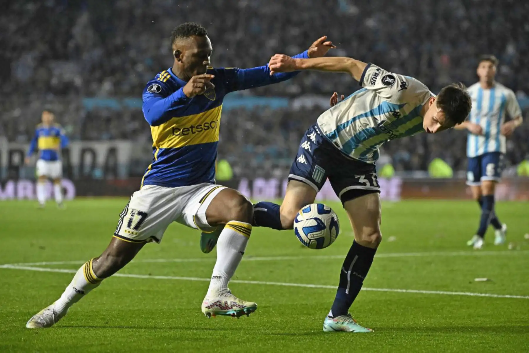 El defensor peruano de Boca Juniors, Luis Advíncula, y el centrocampista de Racing, Baltasar Gallego, luchan por el balón durante el partido de fútbol de segunda vuelta de los cuartos de final de la Copa Libertadores Argentina entre Racing Club y Boca Juniors. Foto: AFP
