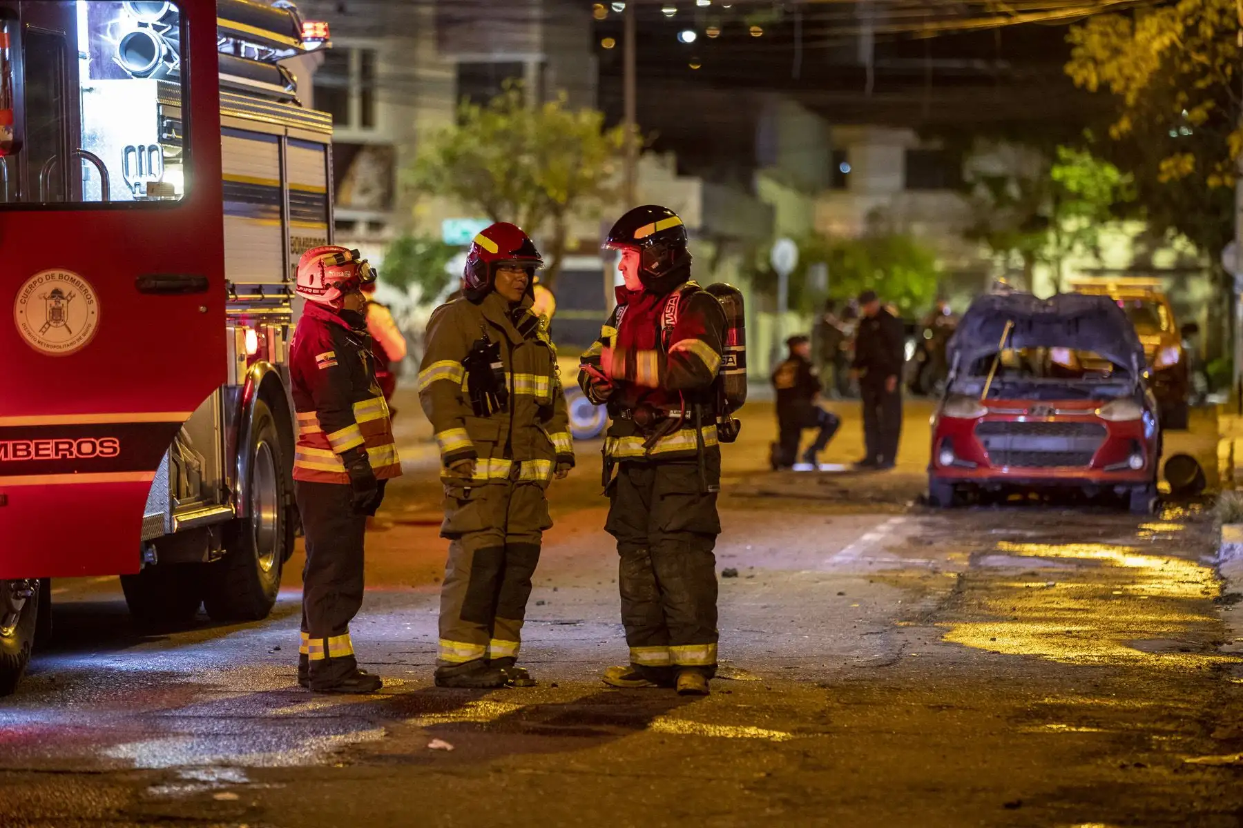 Bomberos resguardan la zona donde un vehículo resulto incendiado hoy en Quito (Ecuador). Un coche resultó incendiado y se escucharon al menos cuatro explosiones en una zona comercial de Quito, en un suceso que generó preocupación ante el clima de violencia que se vive en Ecuador. Foto: EFE
