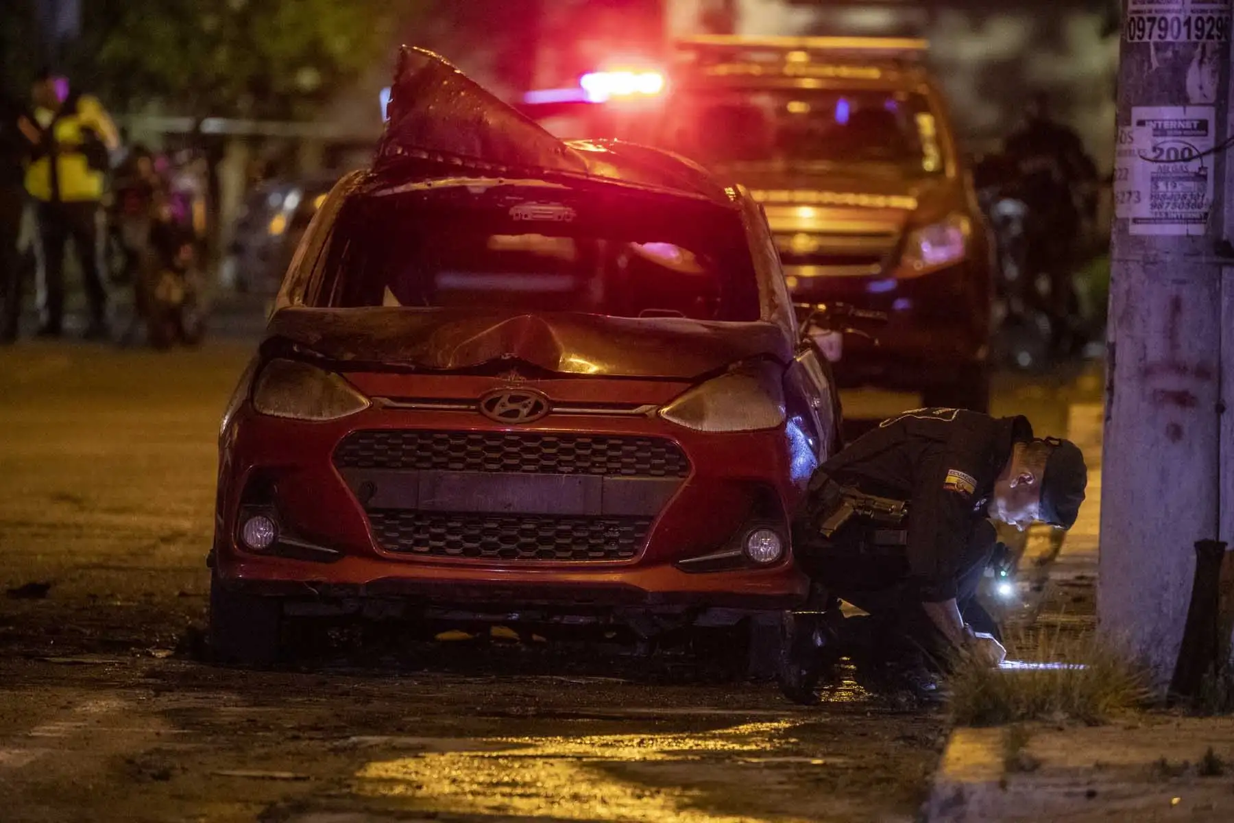 Autoridades resguardan la zona donde un vehículo resulto incendiado hoy en Quito (Ecuador). Un coche resultó incendiado y se escucharon al menos cuatro explosiones en una zona comercial de Quito, en un suceso que generó preocupación ante el clima de violencia que se vive en Ecuador. Foto: EFE