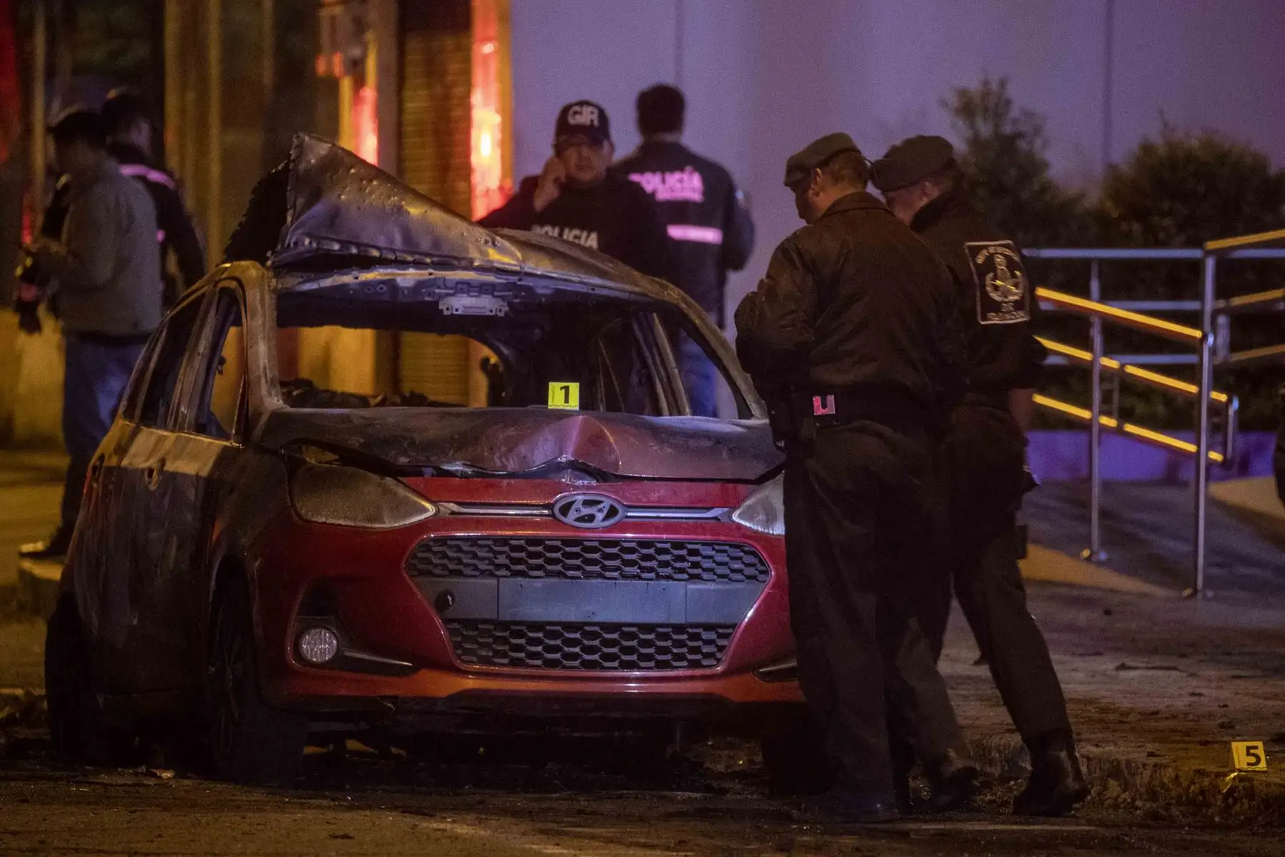 Autoridades resguardan la zona donde un vehículo resulto incendiado hoy en Quito (Ecuador). Un coche resultó incendiado y se escucharon al menos cuatro explosiones en una zona comercial de Quito, en un suceso que generó preocupación ante el clima de violencia que se vive en Ecuador. Foto: EFE