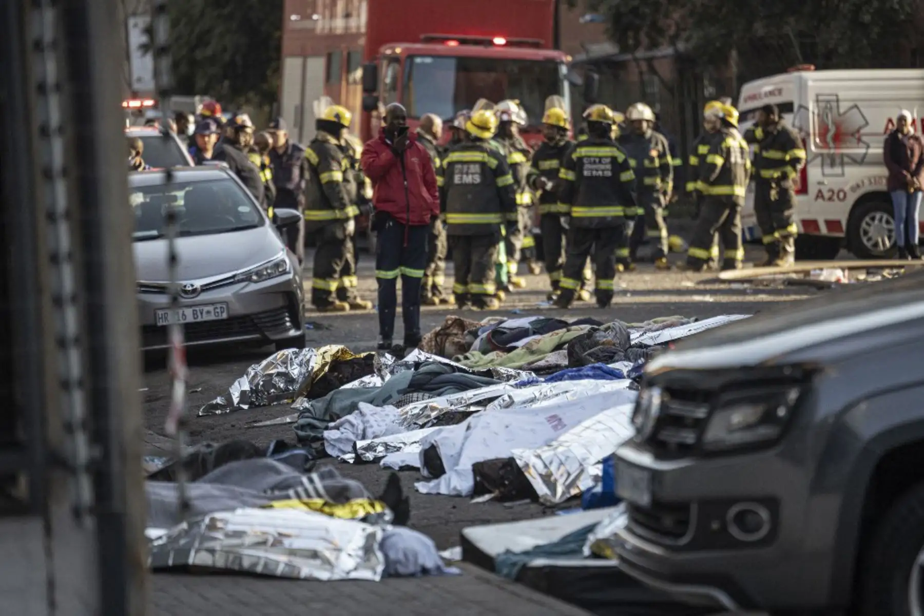 Cuerpos cubiertos con mantas y sábanas en la escena de un incendio en Johannesburgo. Más de 70 personas murieron en un incendio que arrasó un edificio de cinco pisos en el centro de Johannesburgo. Foto: AFP