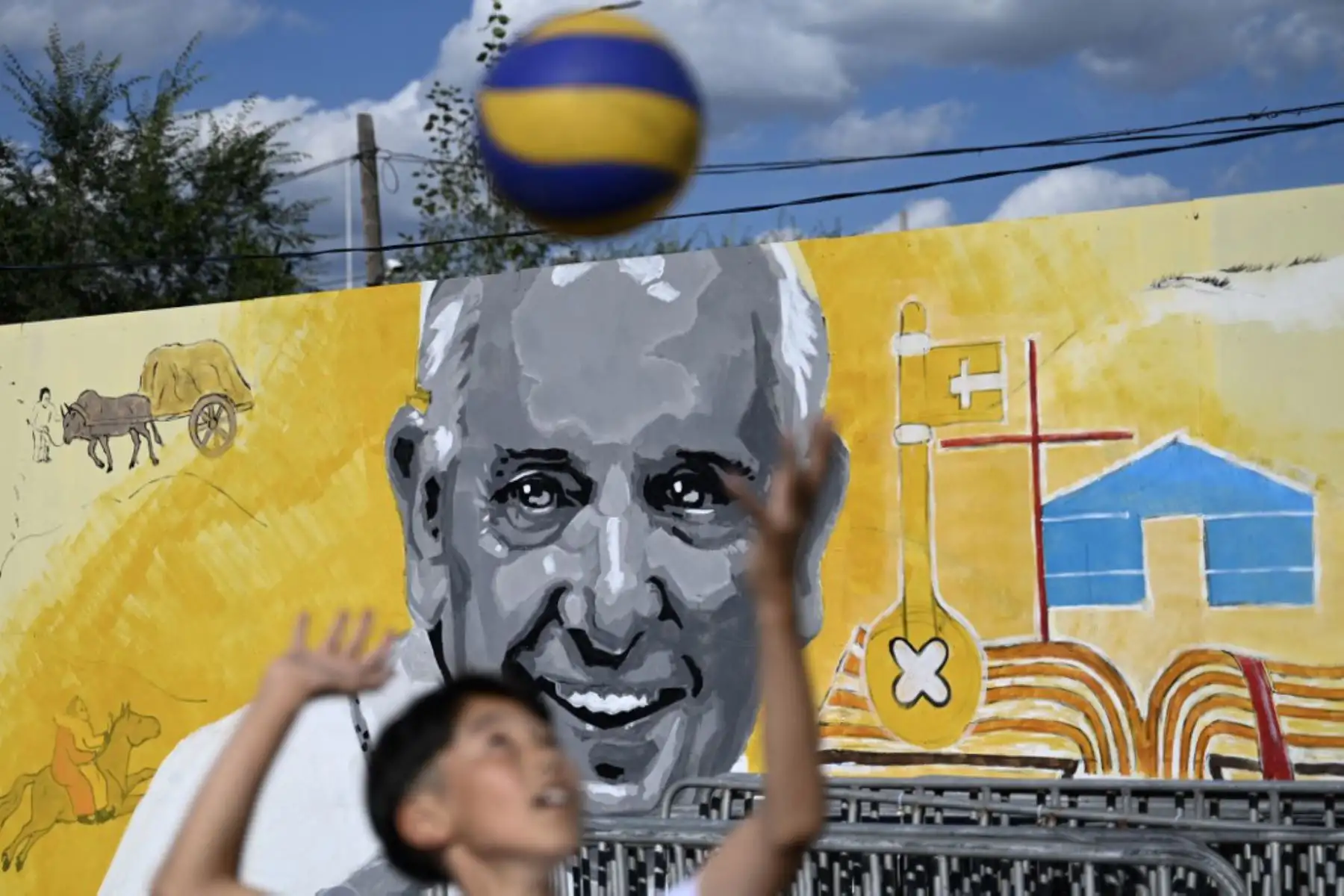 Un niño juega frente a un mural del Papa Francisco en las afueras de Sts. Catedral católica de Pedro y Pablo en Ulán Bator. Foto. AFP