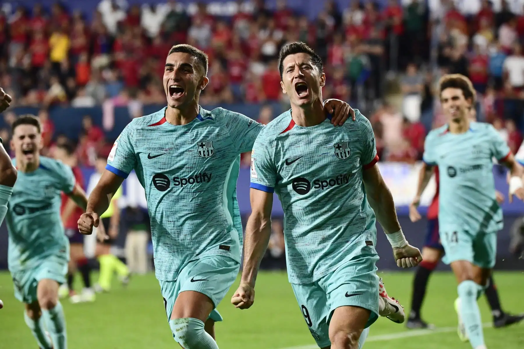 El delantero español del Barcelona  Ferran Torres celebra el gol del delantero polaco del Barcelona Robert Lewandowski marcado desde el punto de penalti durante el partido de fútbol de la Liga española entre el CA Osasuna y el FC Barcelona en el estadio El Sadar de Pamplona.
Foto: AFP