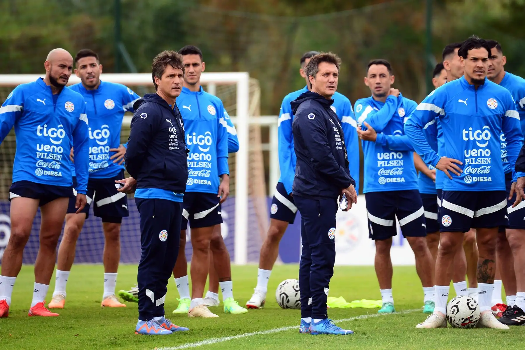 El seleccionador de Paraguay Guillermo Barros Scheloto  y su hermano Gustavo, asistente técnico, observan un entrenamiento hoy, en el centro de entrenamiento CARDE en Ypané (Paraguay). Paraguay se prepara para enfrentar a Perú en la primera fecha de las Eliminatorias Sudamericanas al Mundial de 2026. Foto:ANDINA/ EFE