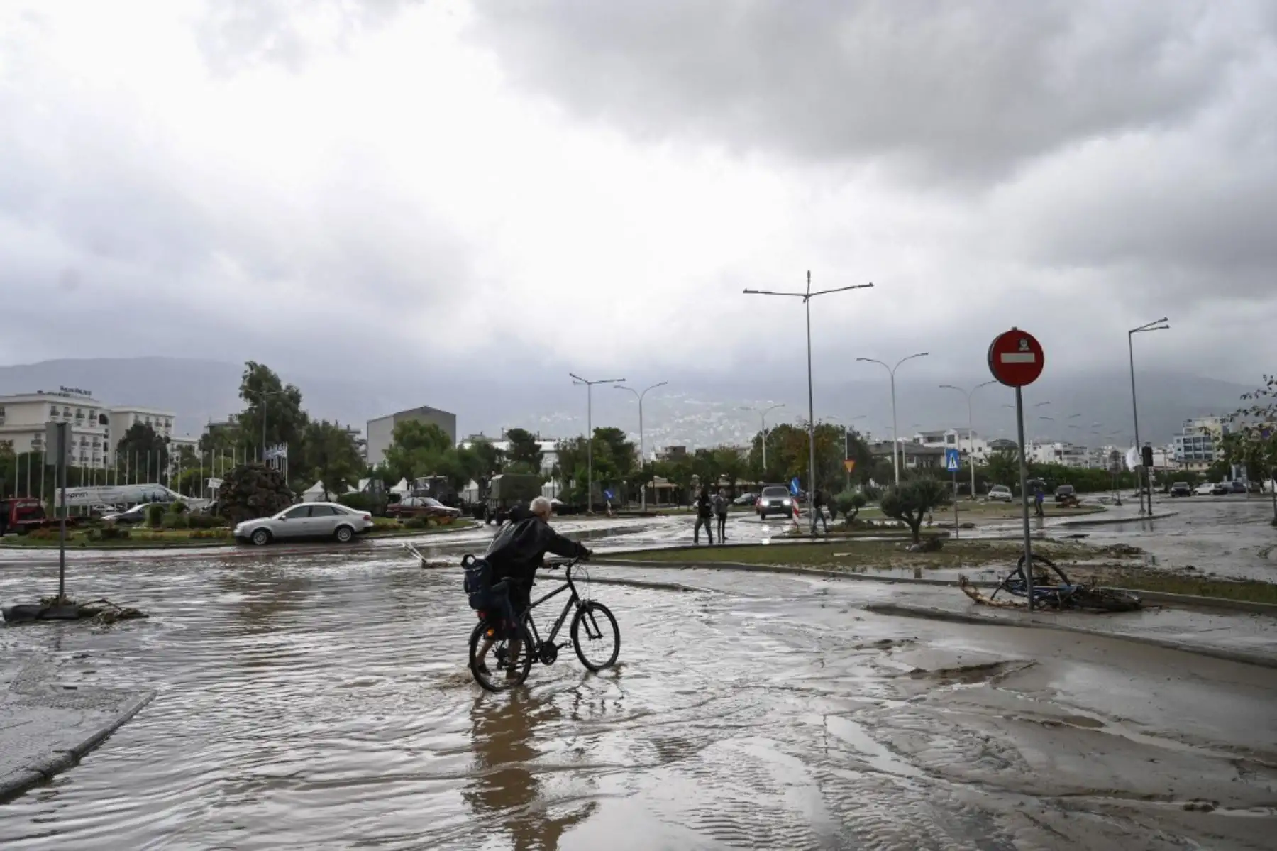 Un hombre anda en bicicleta en una carretera inundada en la ciudad de Volos, Grecia central. Al menos una persona murió en el este de Grecia después de que lluvias torrenciales azotaran el país, ya devastado durante semanas por incendios forestales. Foto: AFP