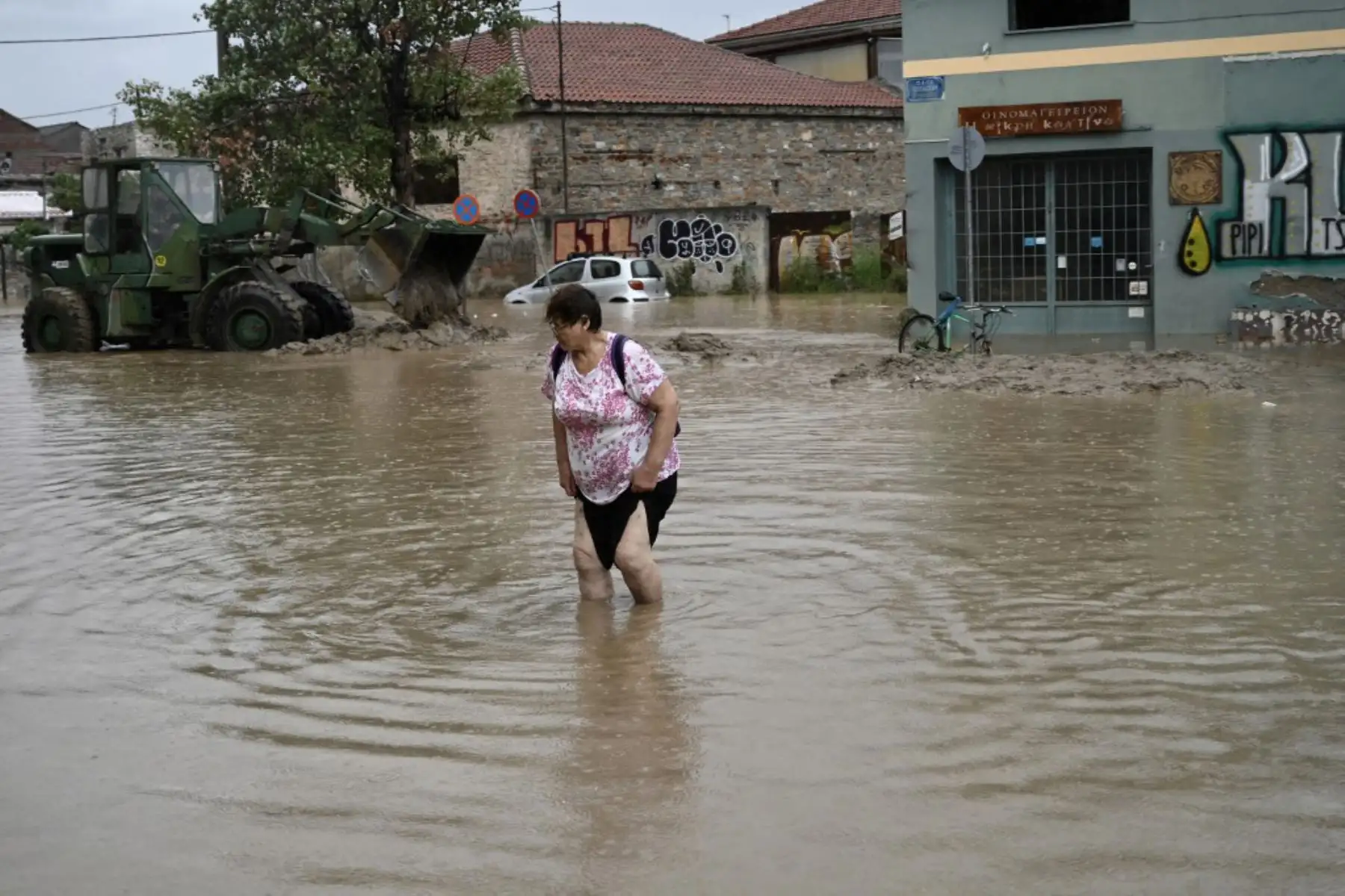 Una mujer camina en una carretera inundada en la ciudad de Volos, Grecia central. Al menos una persona murió en el este de Grecia después de que lluvias torrenciales azotaran el país, ya devastado durante semanas por incendios forestales. Foto: AFP