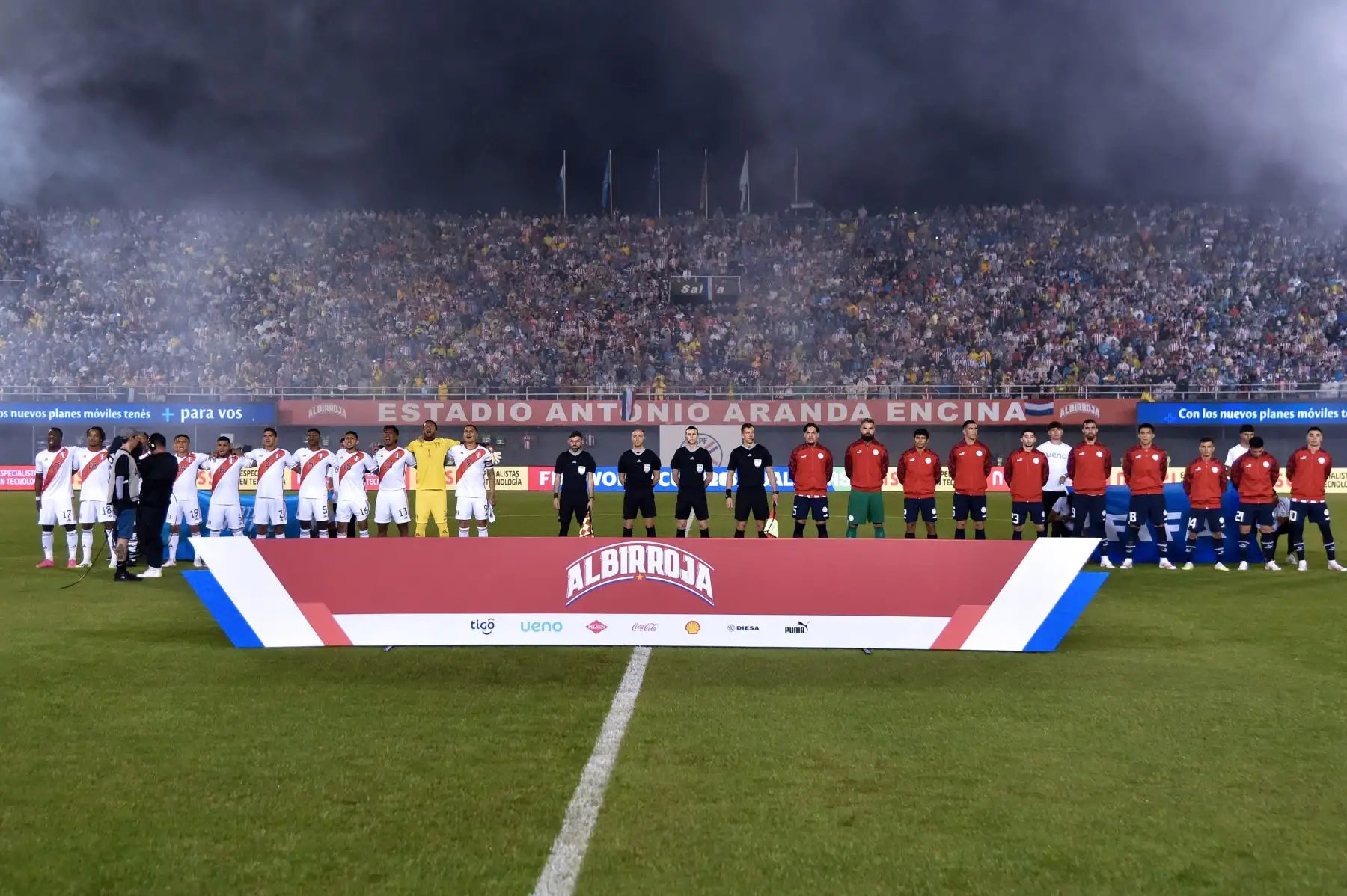 Los jugadores peruanos  y paraguayos cantan sus himnos nacionales antes durante el partido de fútbol de las eliminatorias sudamericanas de la Copa Mundial de la FIFA 2026 entre Paraguay y Perú, en el estadio Antonio Aranda de Ciudad del Este, Paraguay. Foto:ANDINA/AFP