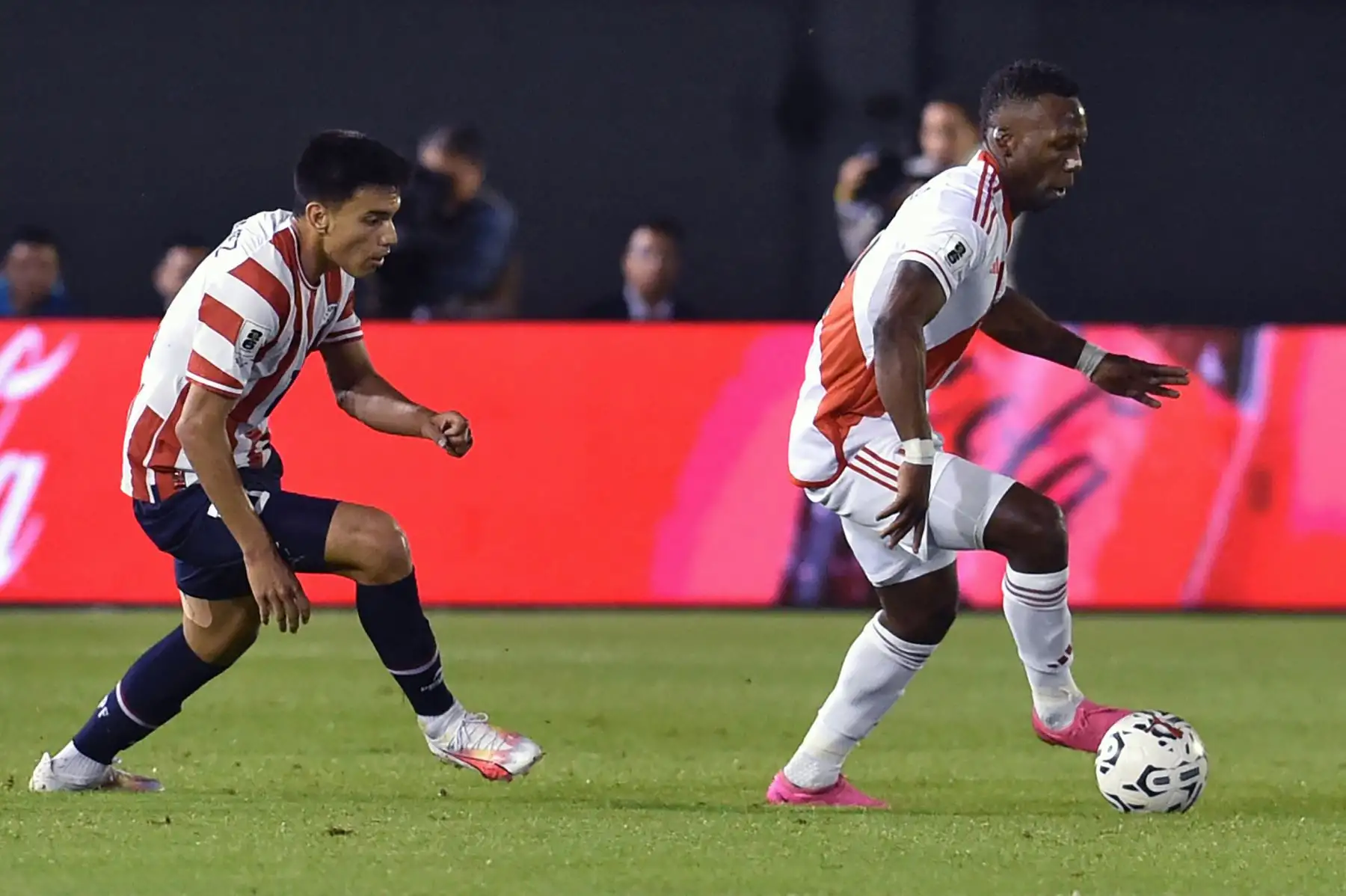 El mediocampista paraguayo Alejandro Romero  lucha por el balón con el defensor peruano Luis Advíncula durante el partido de fútbol de las eliminatorias sudamericanas para la Copa Mundial de la FIFA 2026 entre Paraguay y Perú, en el estadio Antonio Aranda de Ciudad del Este, Paraguay. Foto: ANDINA/AFP