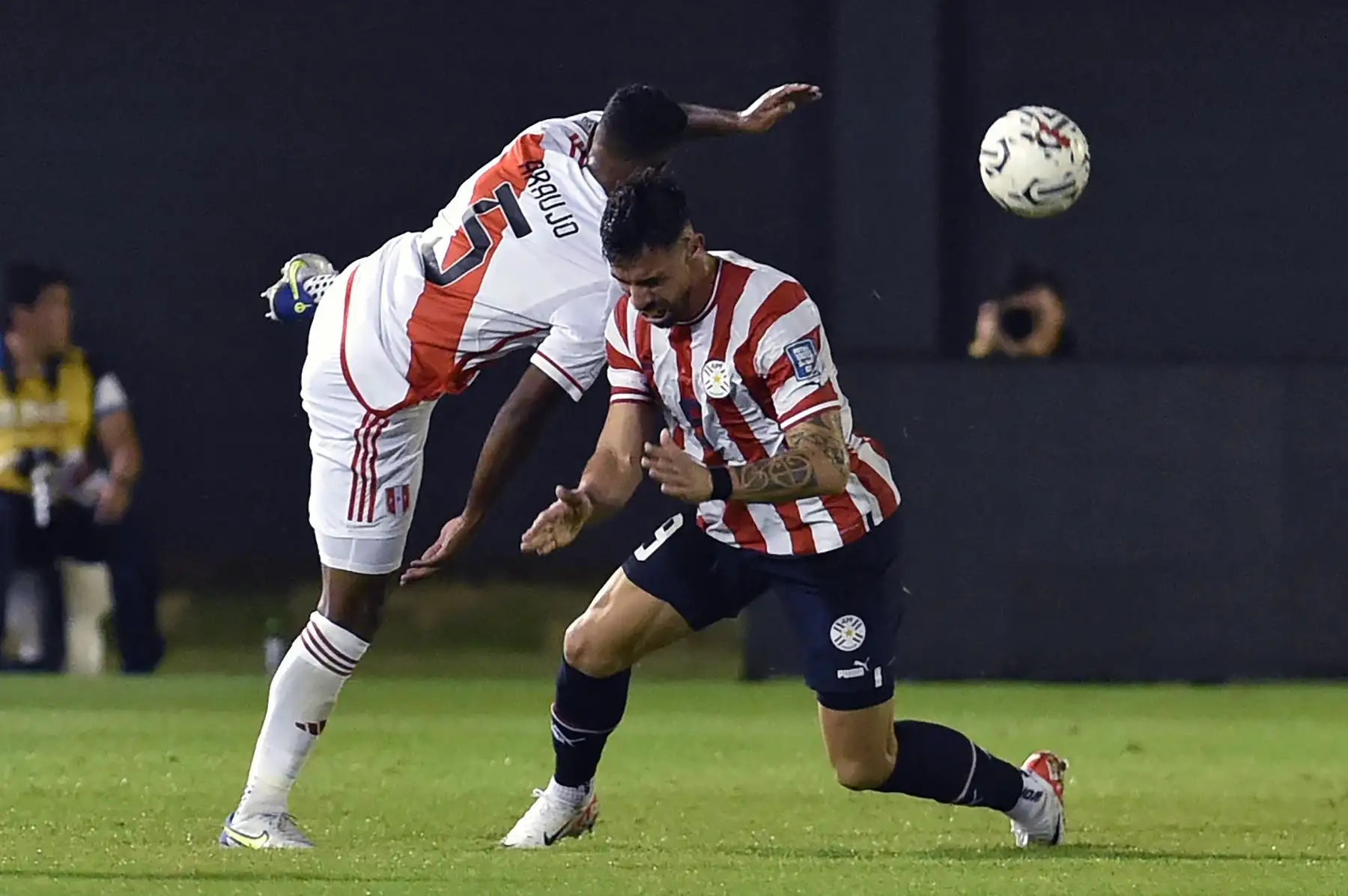 El defensor peruano Miguel Araujo y el delantero paraguayo Gabriel Ávalos luchan por el balón durante el partido de fútbol de las eliminatorias sudamericanas para la Copa Mundial de la FIFA 2026 entre Paraguay y Perú, en el estadio Antonio Aranda de Ciudad del Este, Paraguay. Foto: ANDINA/AFP