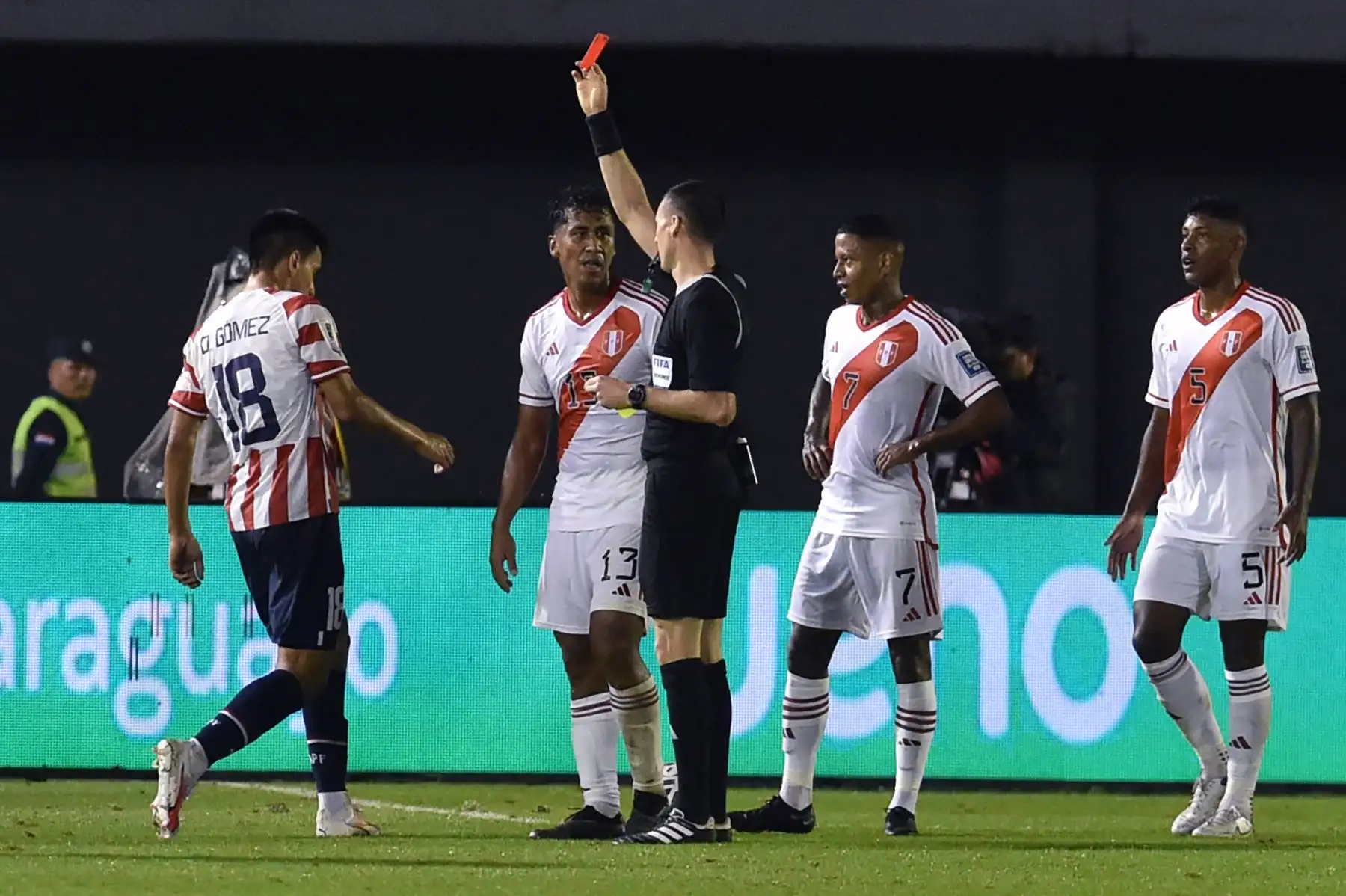 El árbitro uruguayo Andrés Matonte muestra una tarjeta roja al defensor peruano Luis Advíncula  durante el partido de fútbol de las Eliminatorias Sudamericanas para la Copa Mundial de la FIFA 2026 entre Paraguay y Perú, en el estadio Antonio Aranda de Ciudad del Este, Paraguay. Foto:ANDINA/AFP