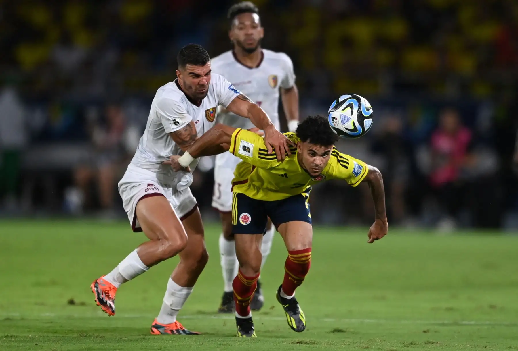 El defensor de Venezuela Alexander González  lucha por el balón con el delantero de Colombia Luis Díaz durante el partido de fútbol de las eliminatorias sudamericanas de la Copa Mundial de la FIFA 2026 entre Colombia y Venezuela en el estadio metropolitano Roberto Meléndez en Barranquilla, Colombia. Foto: ANDINA/ AFP
