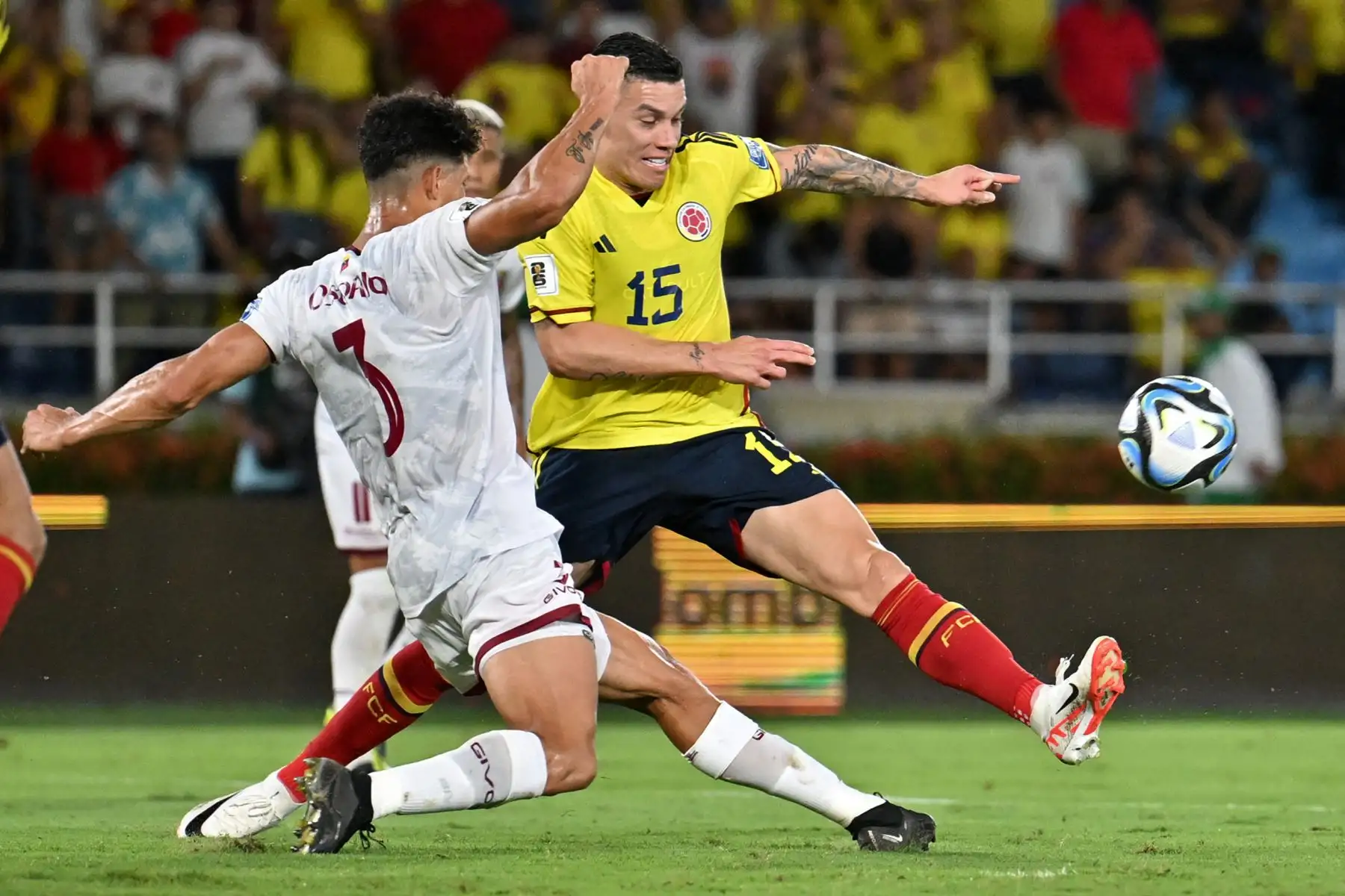 El defensor venezolano Yordan Osorio  lucha por el balón con el mediocampista colombiano Matheus Uribe durante el partido de fútbol de las eliminatorias sudamericanas para la Copa Mundial de la FIFA 2026 entre Colombia y Venezuela en el estadio metropolitano Roberto Meléndez en Barranquilla, Colombia. Foto.ANDINA/AFP
