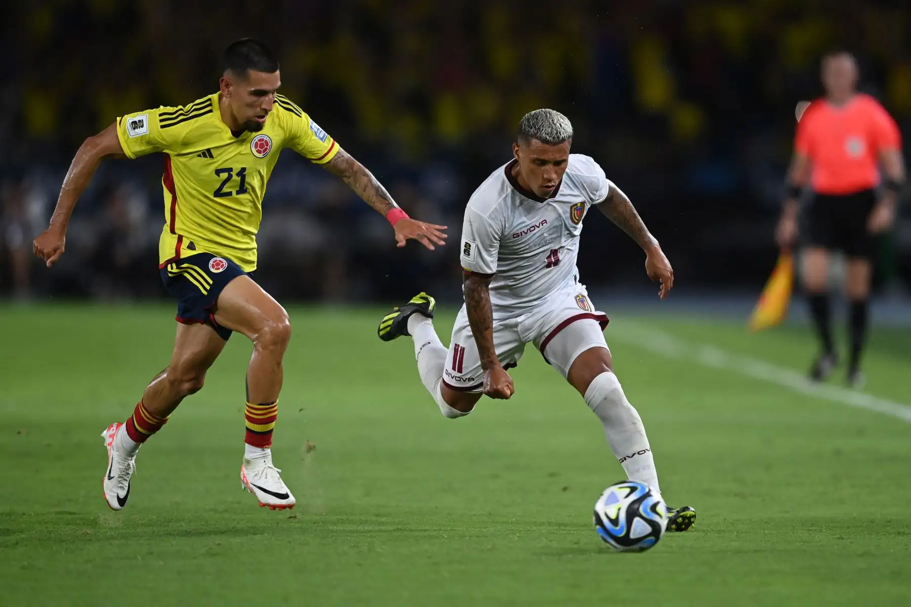 El delantero venezolano Darwin Machis y el defensor colombiano Daniel Muñoz luchan por el balón durante el partido de fútbol de las eliminatorias sudamericanas para la Copa Mundial de la FIFA 2026 entre Colombia y Venezuela en el estadio metropolitano Roberto Meléndez en Barranquilla, Colombia. Foto. ANDINA/AFP