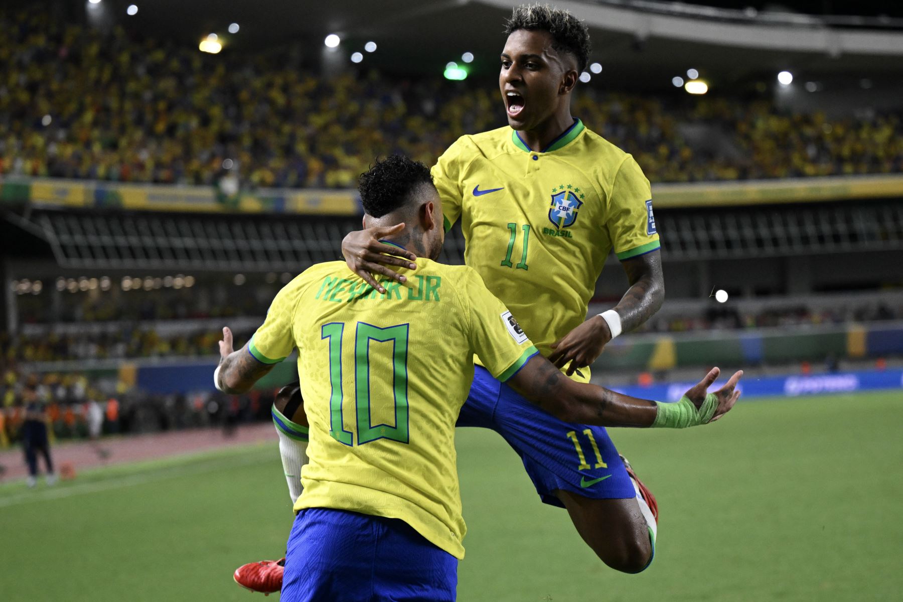 El delantero brasileño Neymar celebra con su compañero de equipo Rodrygo después de marcar un gol durante el partido de fútbol de las eliminatorias sudamericanas con miras al Mundial 2026. Foto: AFP