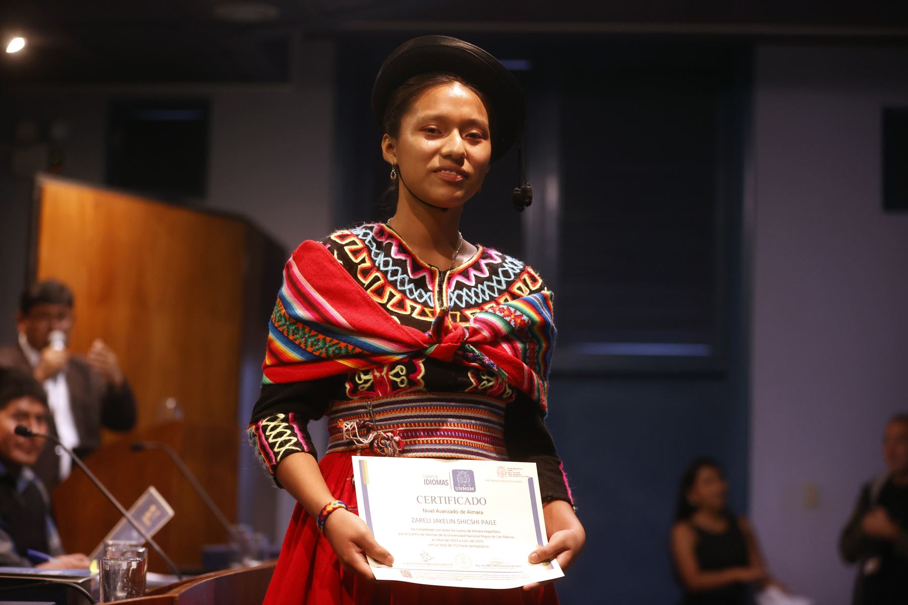 Zareli Shicshi recibe su certificado en la graduaciòn de la primnera promoción de lengua aimara, autodenominada "Kutt