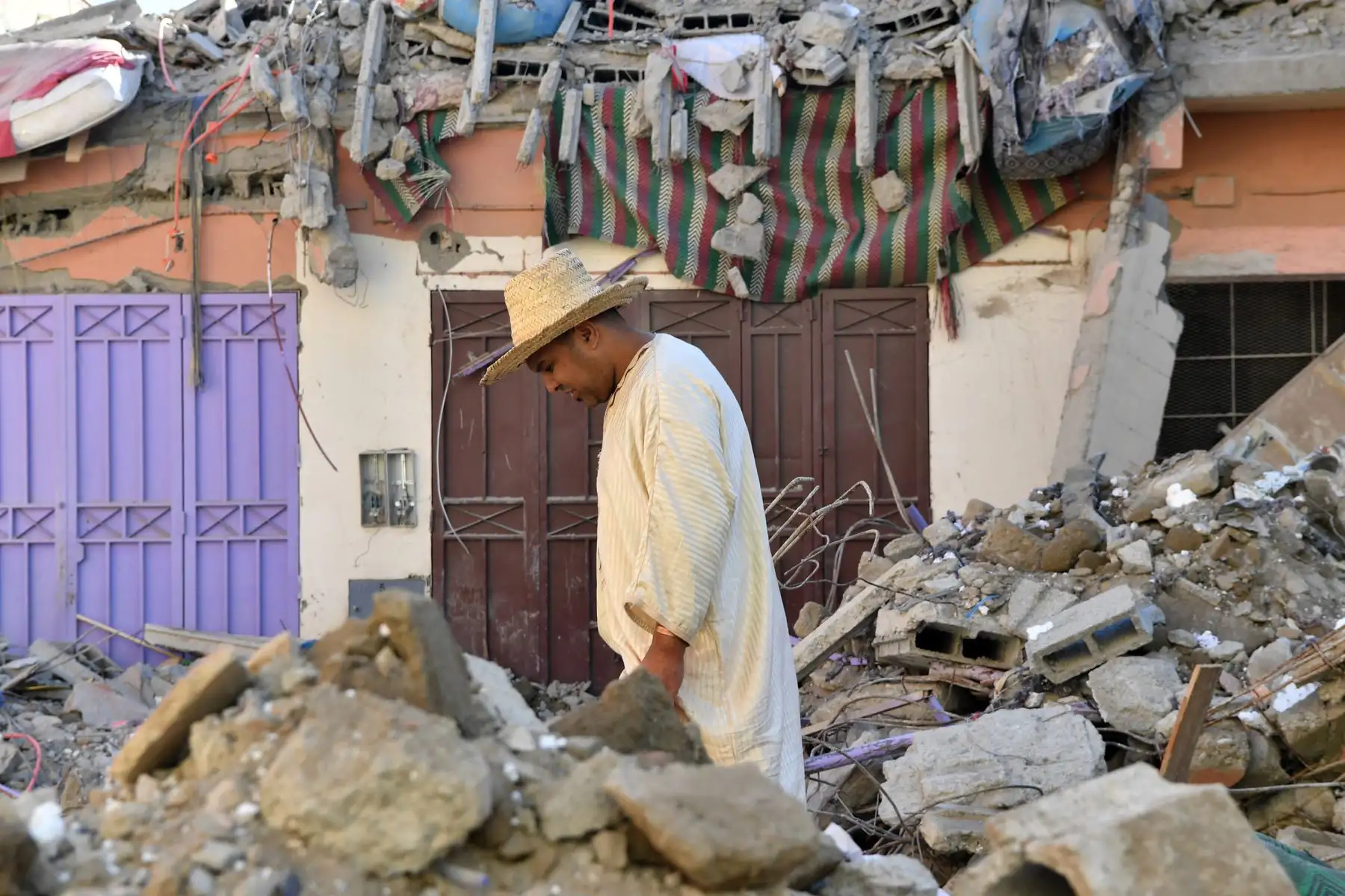 Un residente camina entre los escombros de un edificio en la aldea de Mzouda, en la provincia marroquí de Chichaoua, tras un devastador terremoto ocurrido el 10 de septiembre de 2023. El 10 de septiembre, los marroquíes lloraron a las víctimas de un terremoto, el más fuerte que jamás haya azotado el país, que mató a más de 2.000 personas. mientras los equipos de rescate se apresuraban a encontrar supervivientes atrapados entre los escombros de las aldeas arrasadas.Foto: AFP