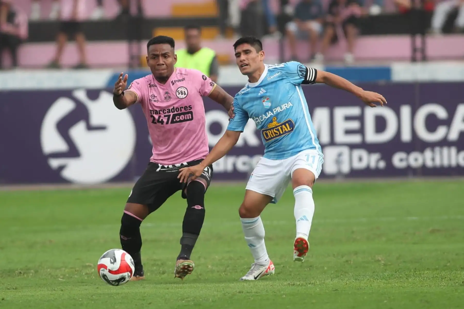 El jugador Irven Ávila del Sporting Cristal disputa 
el balón contra futbolista del Sport Boys, por la fecha 12 del Torneo Clausura en el estadio Miguel Grau del Callao. 
Foto: ANDINA/ Ricardo Cuba