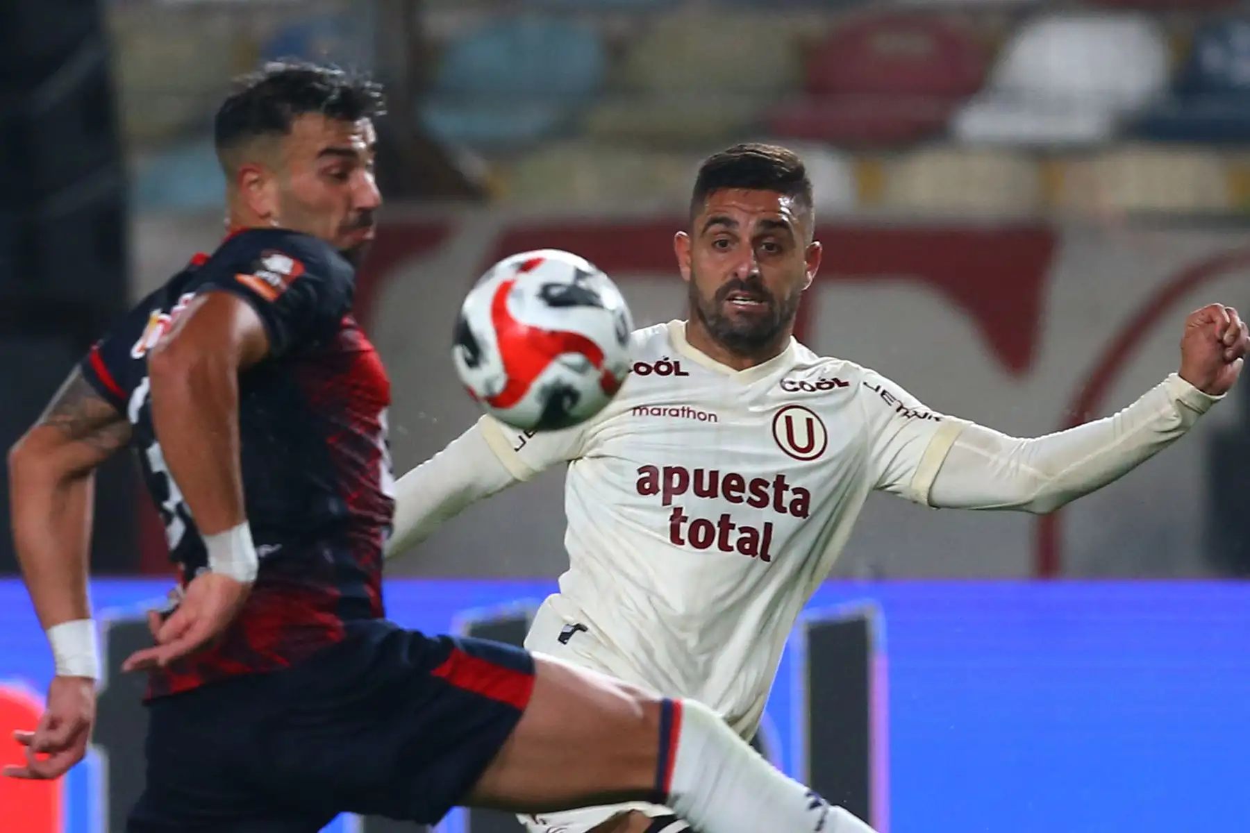 El jugador de Universitario, Luis Urruti disputa el balón ante el jugador de Deportivo Municipal por la fecha 12 del Torneo Clausura en el estadio Monumental de Ate. 

Foto: Andina/ Eddy Ramos