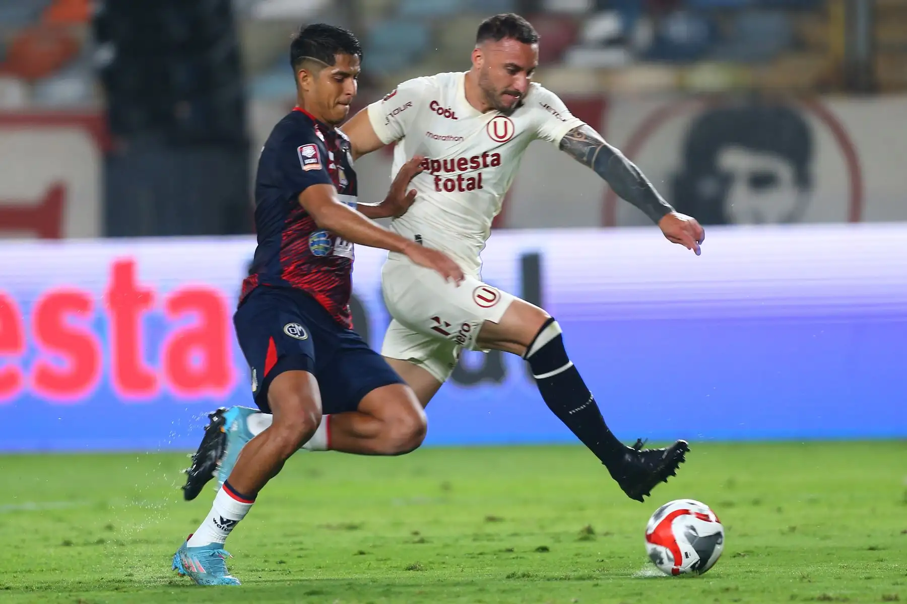 El jugador de Universitario, Emanuel Herrera disputa el balón ante el jugador de Deportivo Municipal por la fecha 12 del Torneo Clausura en el estadio Monumental de Ate. 

Foto: Andina/ Eddy Ramos
