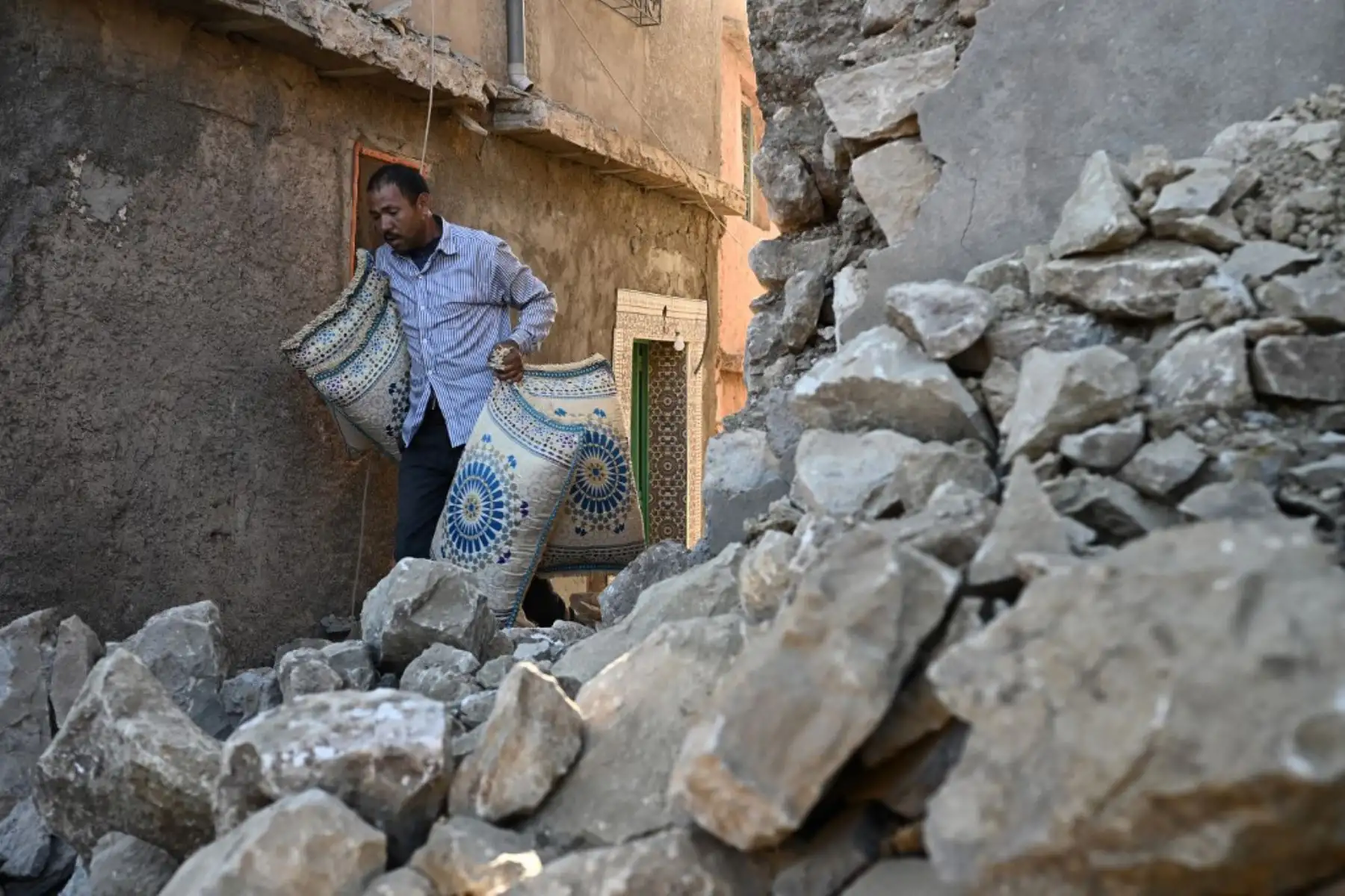 Un hombre pasa junto a casas destruidas en el pueblo de montaña de Moulay Brahim. Foto: AFP