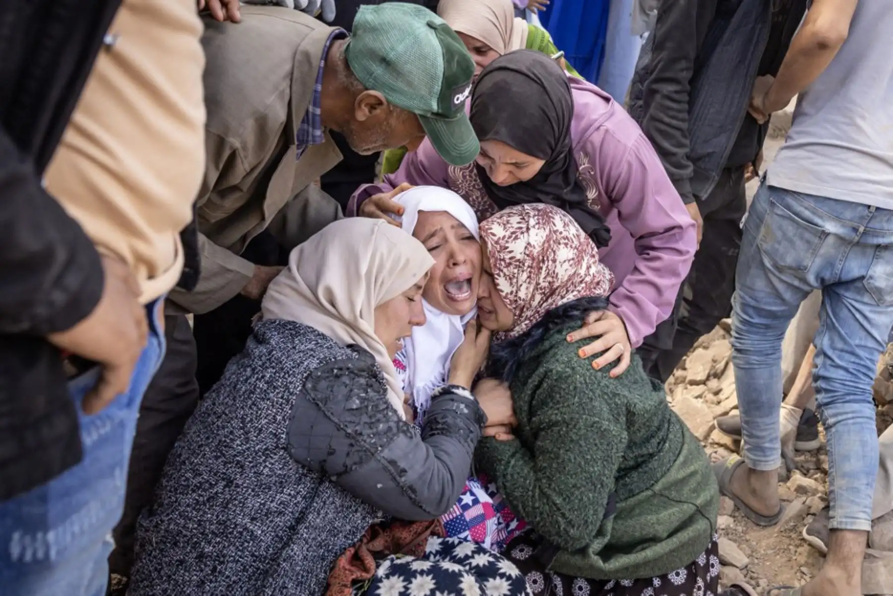 Mujeres lloran cuando los voluntarios recuperan el cuerpo de un miembro de su familia de los escombros de las casas derrumbadas en la aldea de Imi N