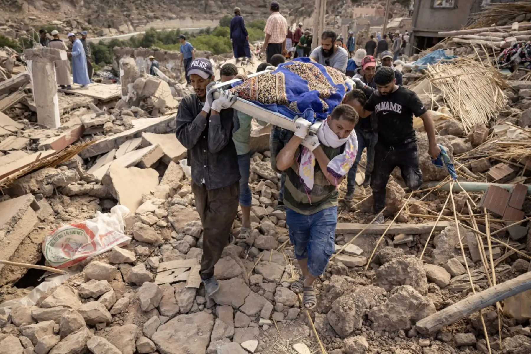 Voluntarios llevan los restos de una víctima del mortal terremoto de magnitud 6,8 ​​del 8 de septiembre, en la aldea de Imi N