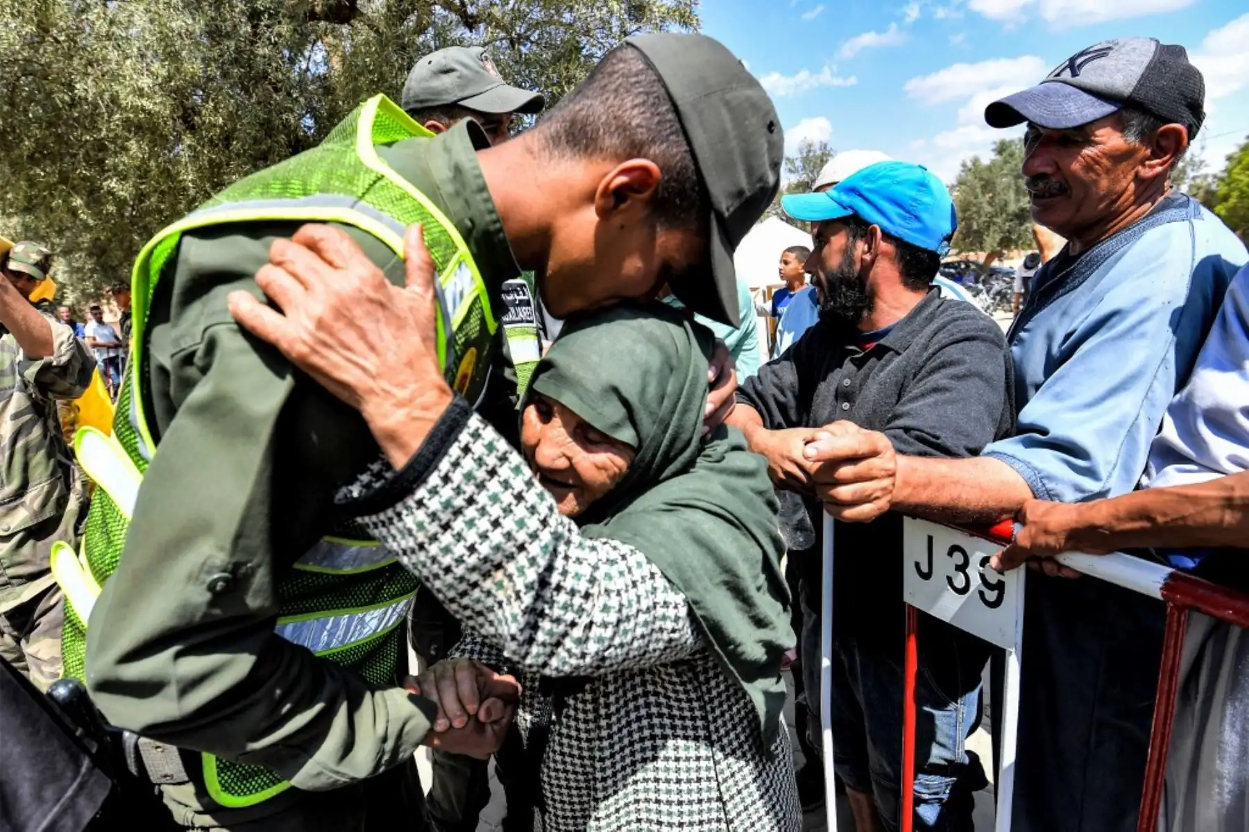 Un miembro de las Fuerzas Auxiliares de Marruecos abraza a una anciana que llega para recibir ayuda en un centro de distribución en la ciudad de Amizmiz, en el centro de Marruecos. Foto: AFP